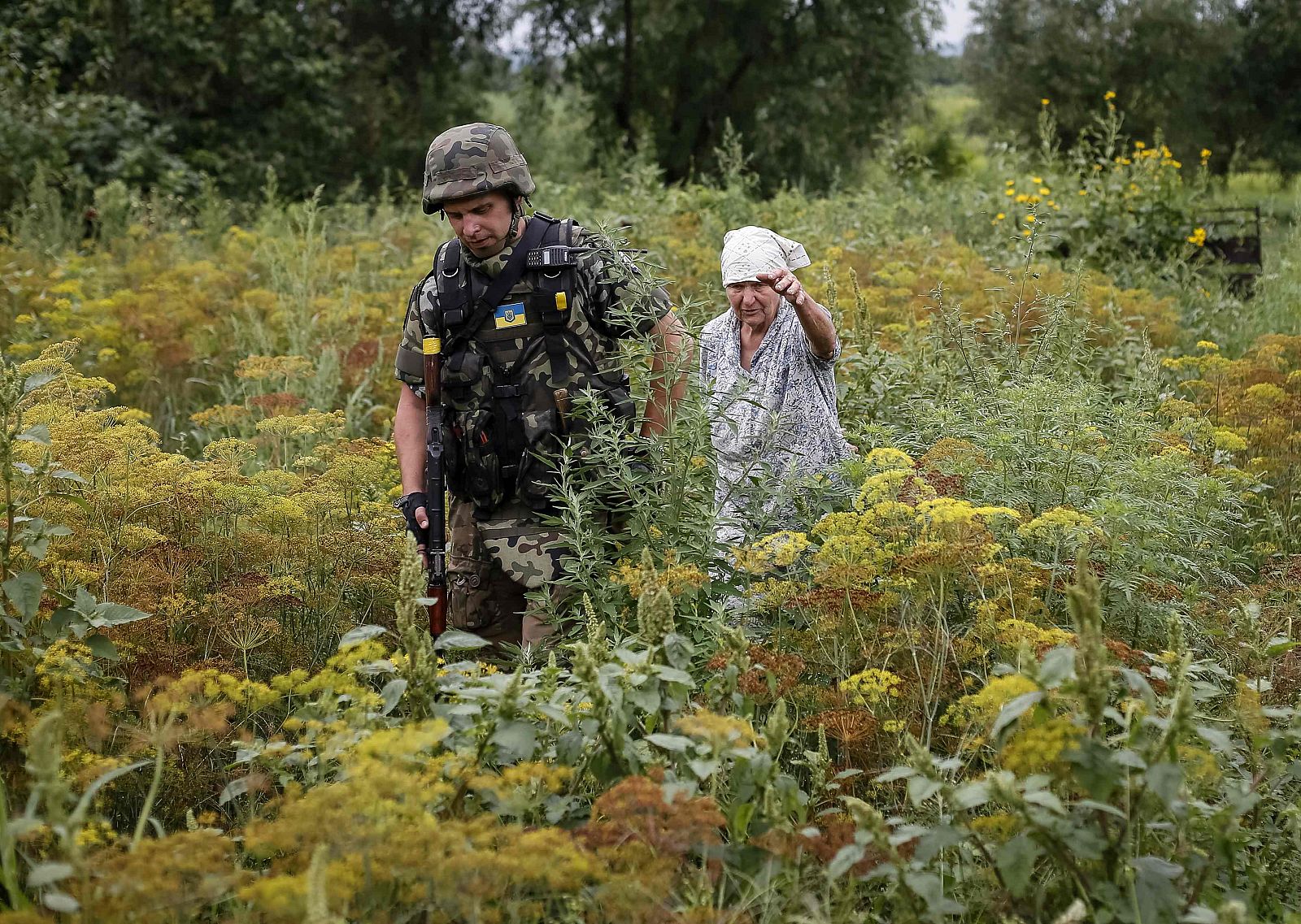 Una vecina junto a un oficial ucraniano durante una patrulla este lunes en la localidad de Semenovka, cerca de Slaviansk.