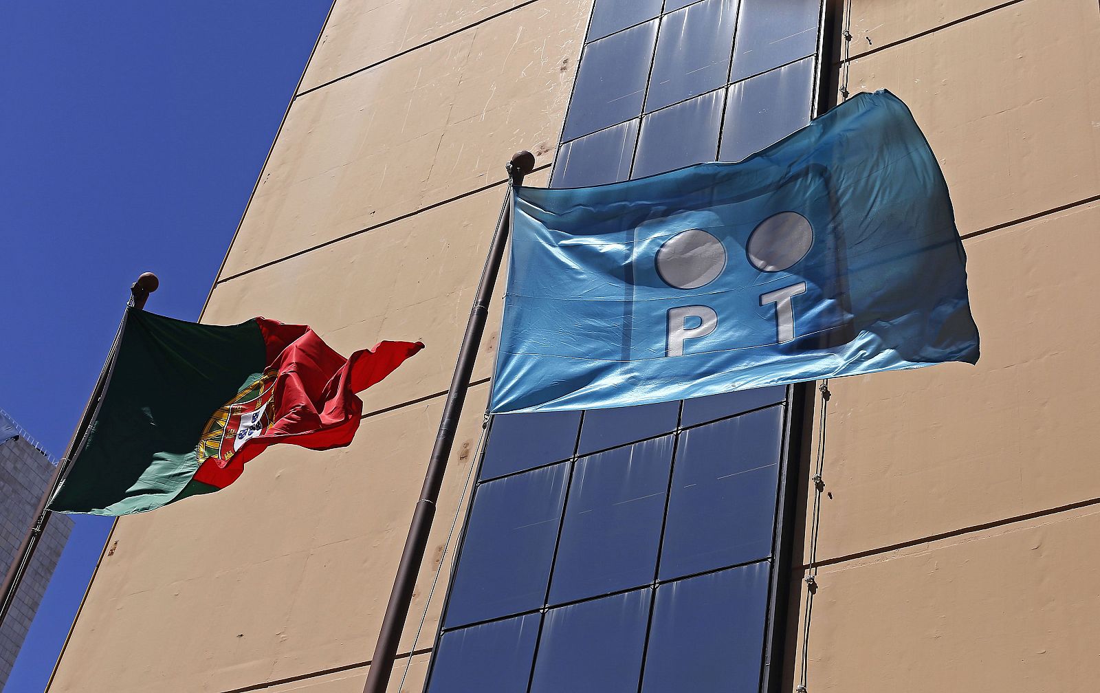 Una bandera de Portugal Telecom ondea junto a otra del país en la sede de la 'teleco'