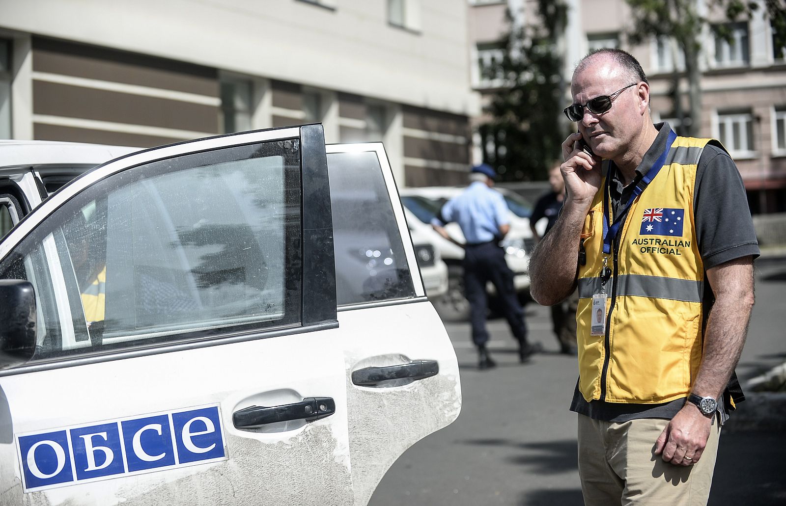 Un forense australiano habla por teléfono en Donetsk, de donde no pueden salir a investigar el derribo del avión malasio por la inseguridad en la zona.