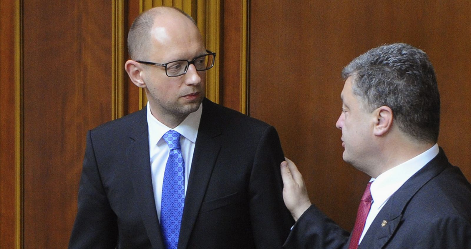 El presidente de Ucrania, Petro Poroshenko habla con el primer ministro Arseni Yatseniuk durante la sesión parlamentaria que ha rechazado su dimisión.