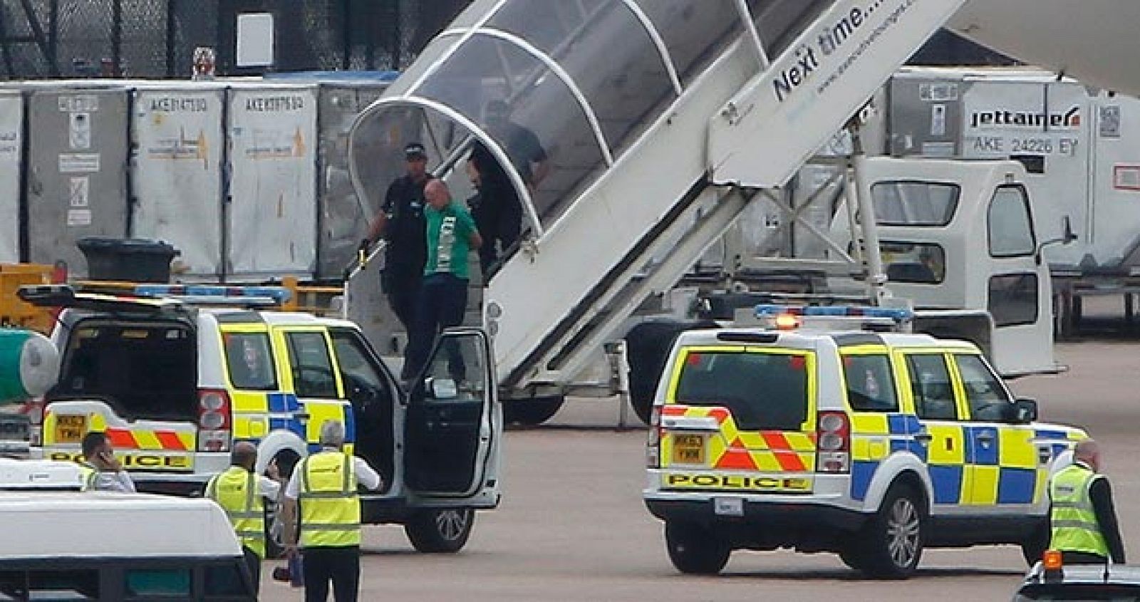 Un hombre es escoltado por la policía en el aeropuerto de Manchester (Inglaterra) tras un falso aviso de bomba