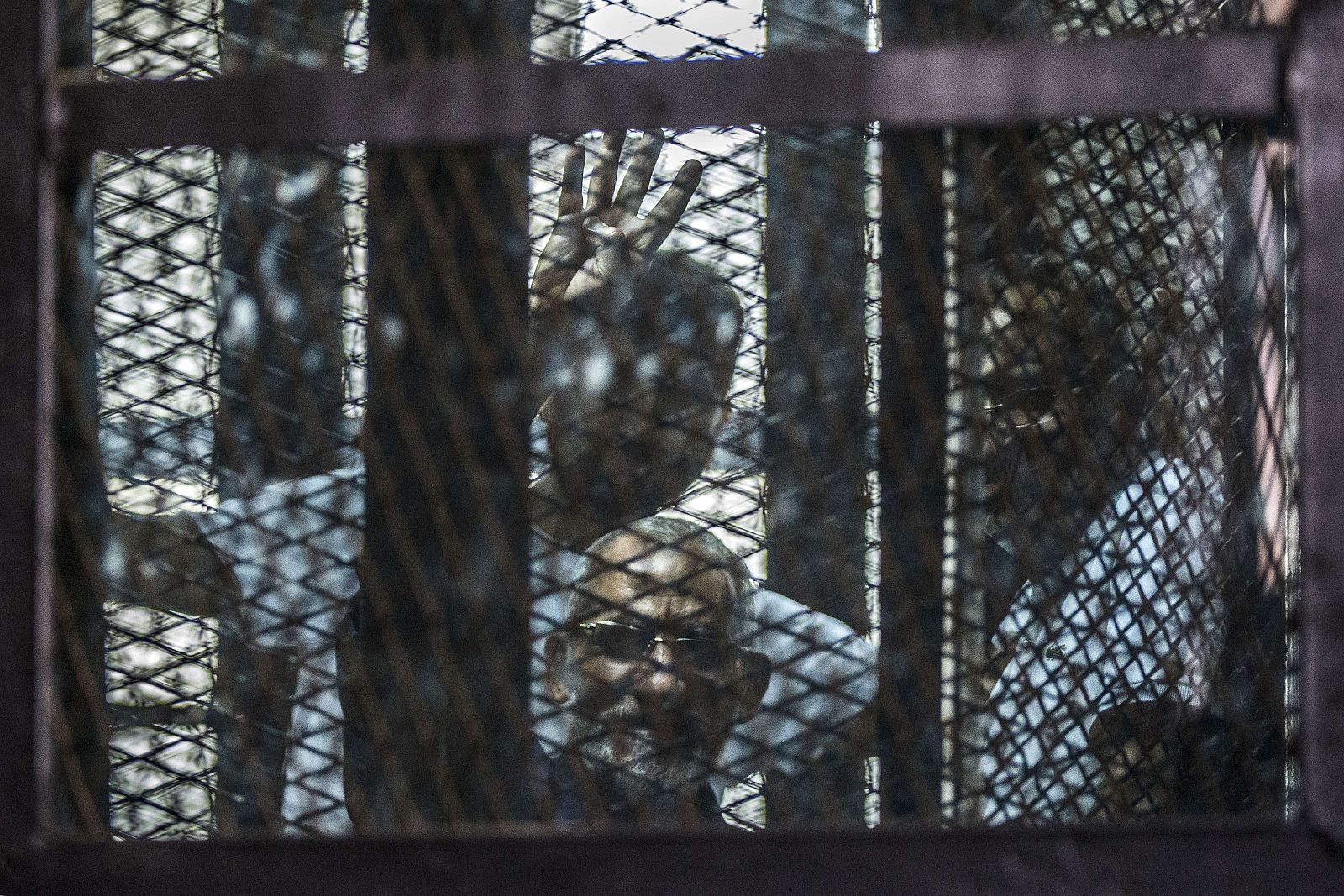 El líder de los Hermanos Musulmanes, Mohamed Badie, hace gestos desde la celda en la que atiende su juicio en la prisión de Tura (Egipto), el 3 de agosto de 2014