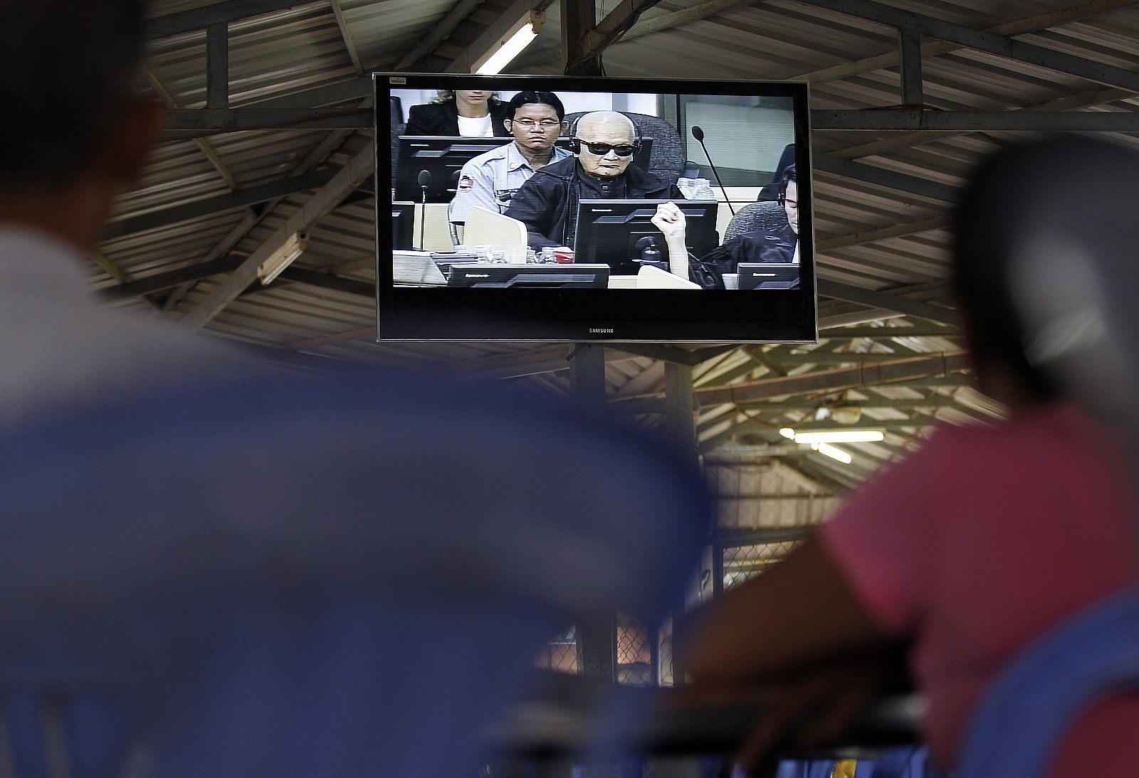 Camboyanos observan la transmisión de televisión del juicio a Nuon Chea en Phnom Penh.