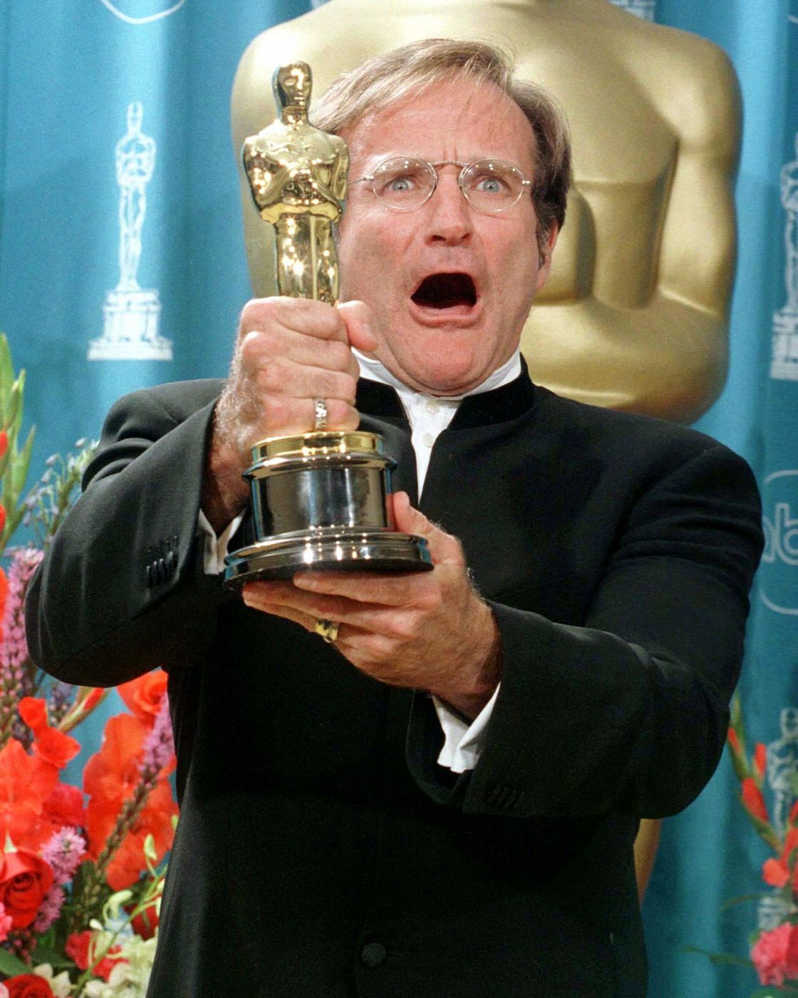 El actor Robin Williams muestra su Oscar por su papel secundario en la película 'El indomable Will Hunting'.