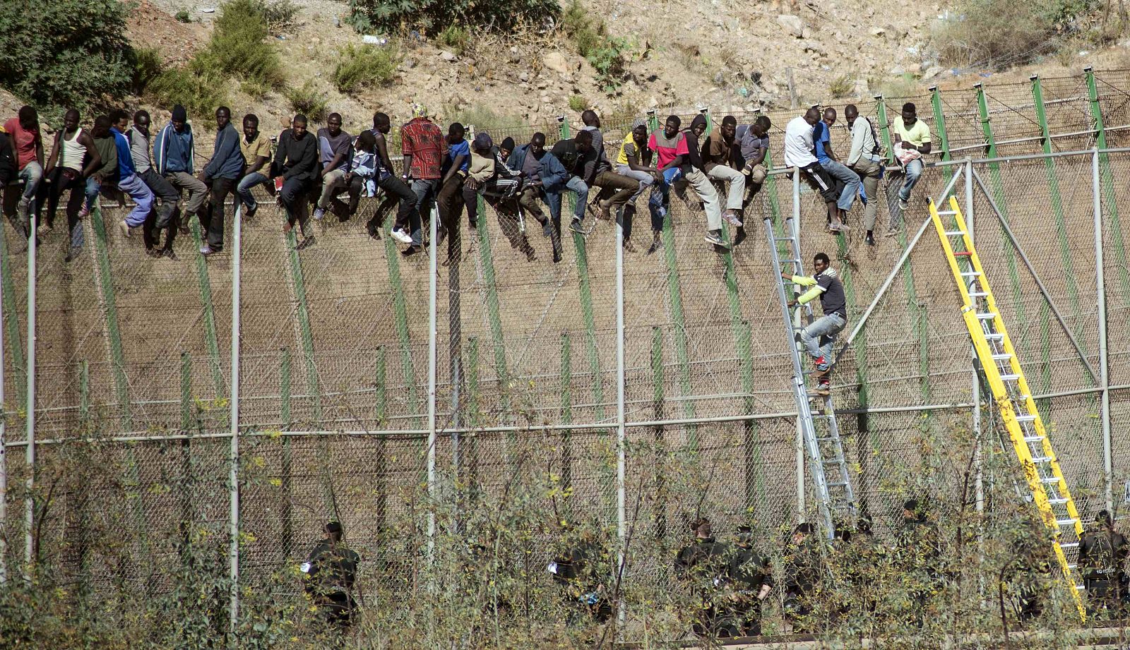 Inmigrantes subsaharianos encaramados a la valla de Melilla.