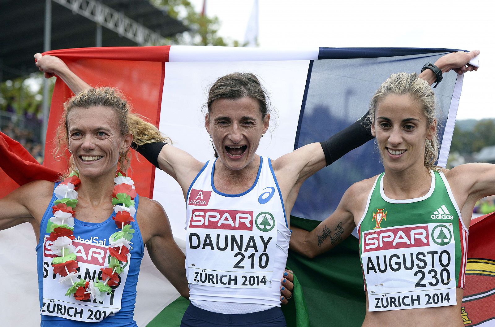 La frances Christelle Daunay (C) celebra su victoria ante la italiana Valeria Straneo (I) y la portuguesa Jessica Augusto (D).