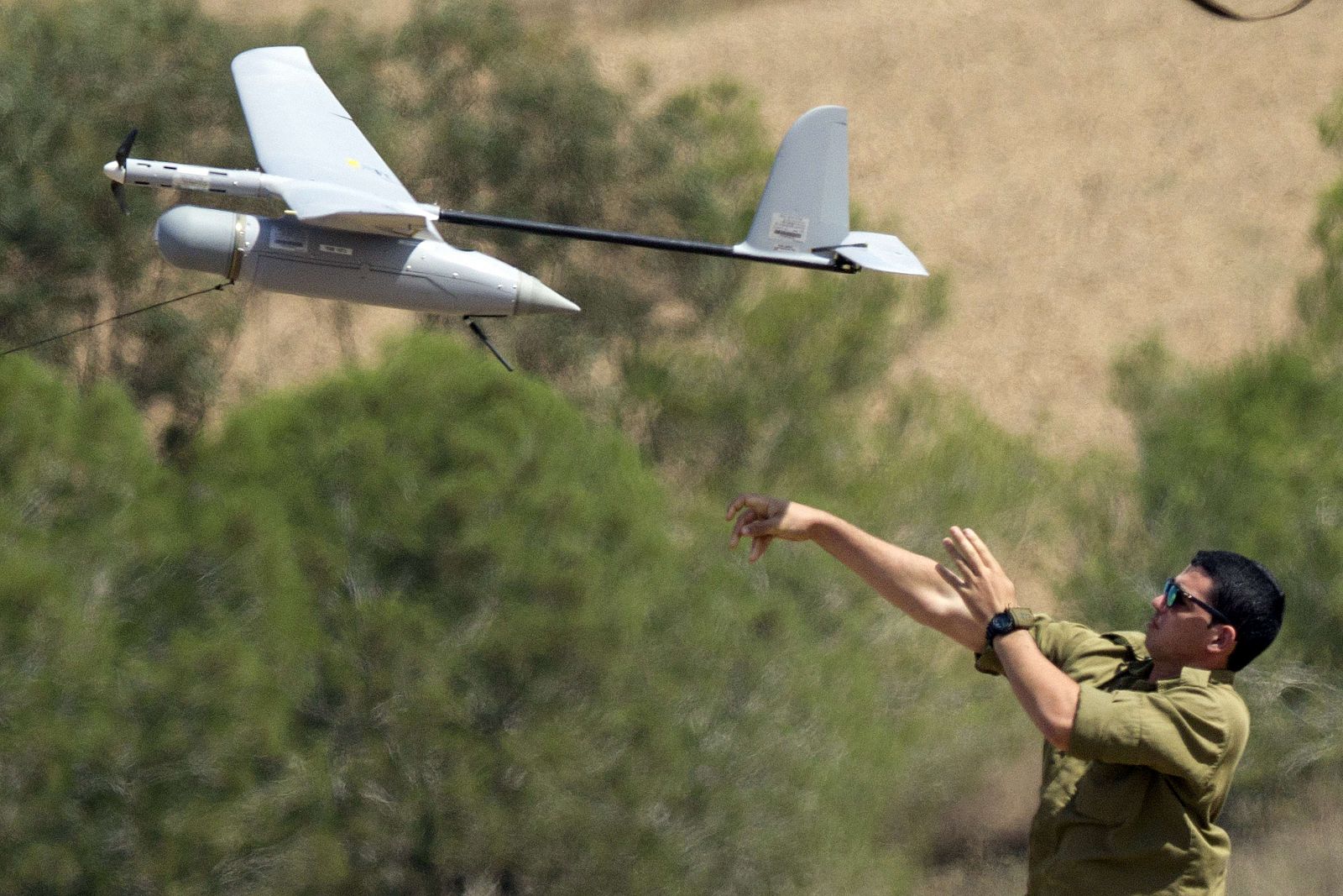 Un soldado israelí lanza un pequeño drone de vigilancia cerca de la frontera palestina.