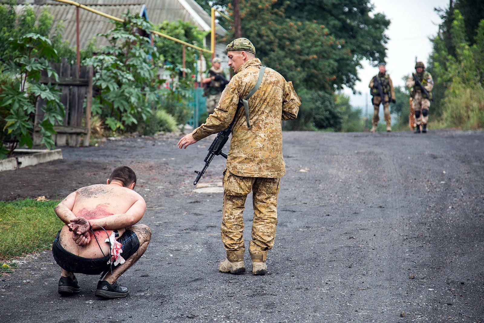 Un soldado ucraniano junto a un rebelde prorruso arrestado.