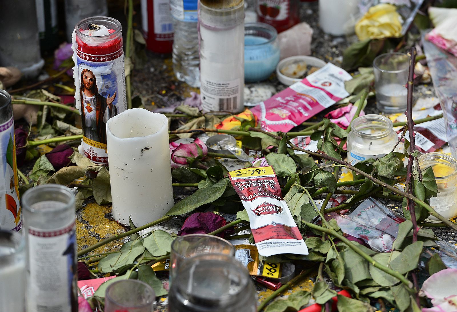 Vista de velas y otros objetos en el lugar donde murió el joven Michael Brown, en Ferguson, Misuri (EE.UU.).