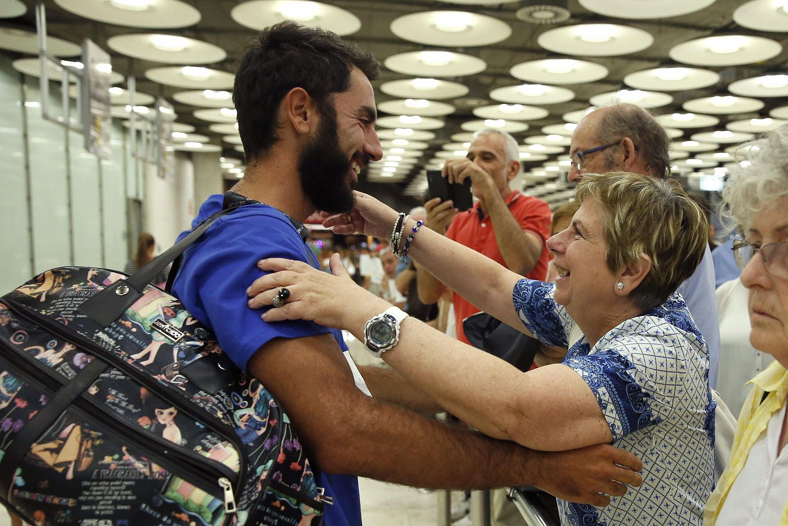 Rafael Martínez, periodista de la Agencia Efe, uno de los dos españoles supervivientes del naufragio de un barco turístico en aguas de Indonesia, saluda a su madre a su llegada al aeropuerto Adolfo Suárez Madrid-Barajas.