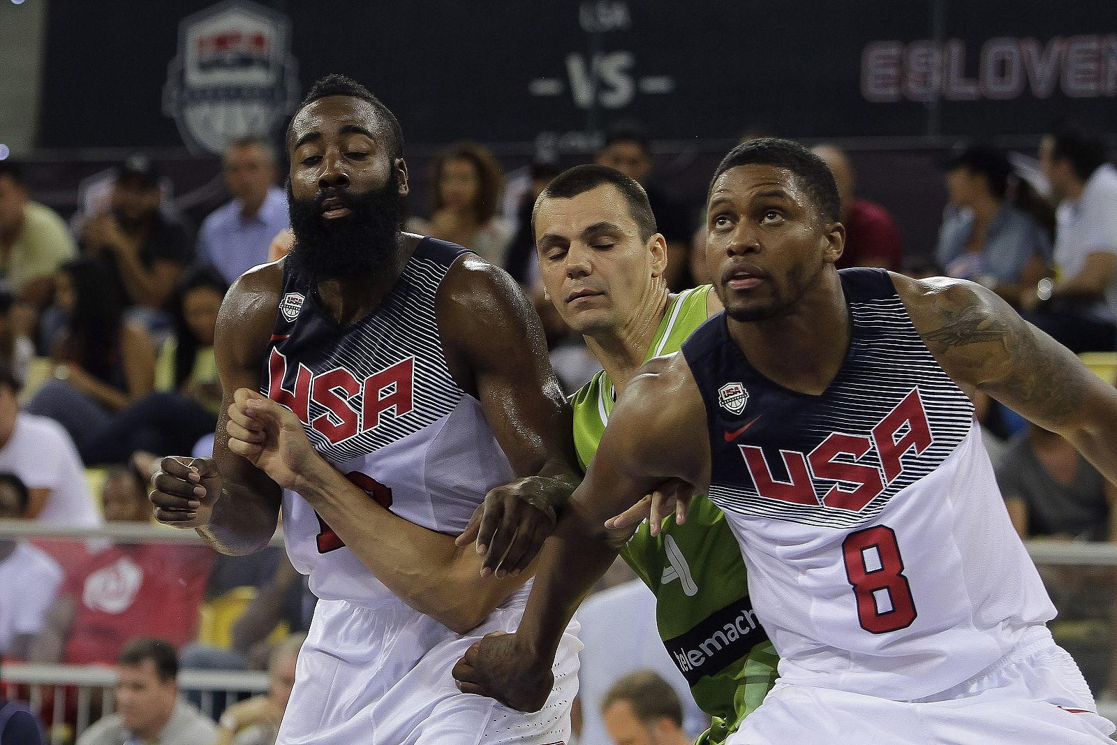 Los jugadores de Estados Unidos, James Harden (i) y Rudy Gay (d), luchan la posición con Jure Balazic (c).