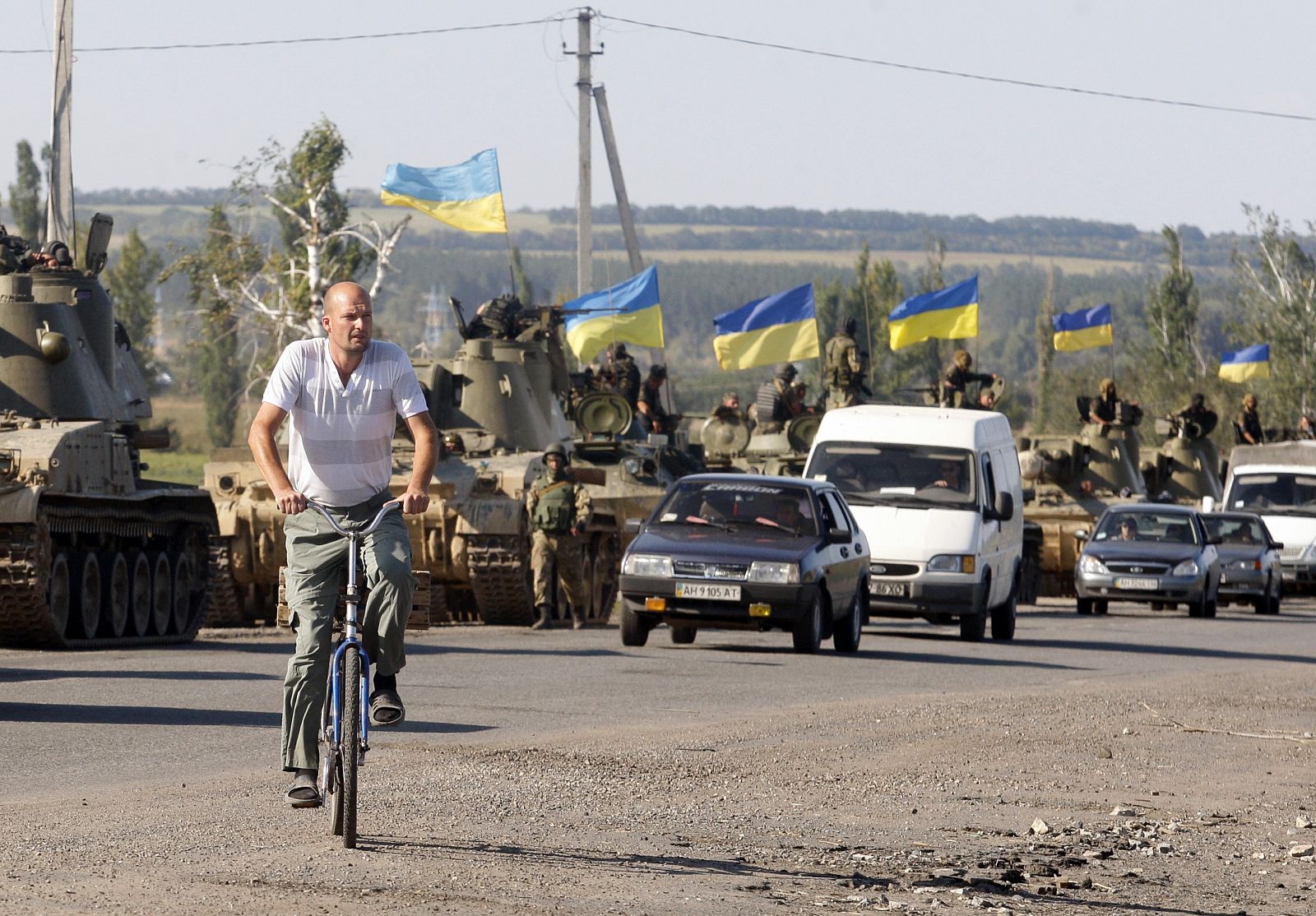 Un residente de Donetsk pasa delante de una columna de tanques del ejército de Ucrania