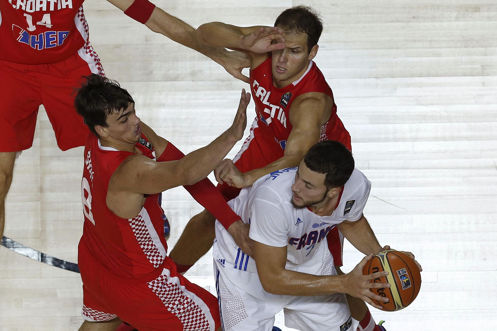 El ala-pívot de Francia Joffrey Lauvergne (d) controla el balón ante Bojan Bogdanovic y Dario Saric.