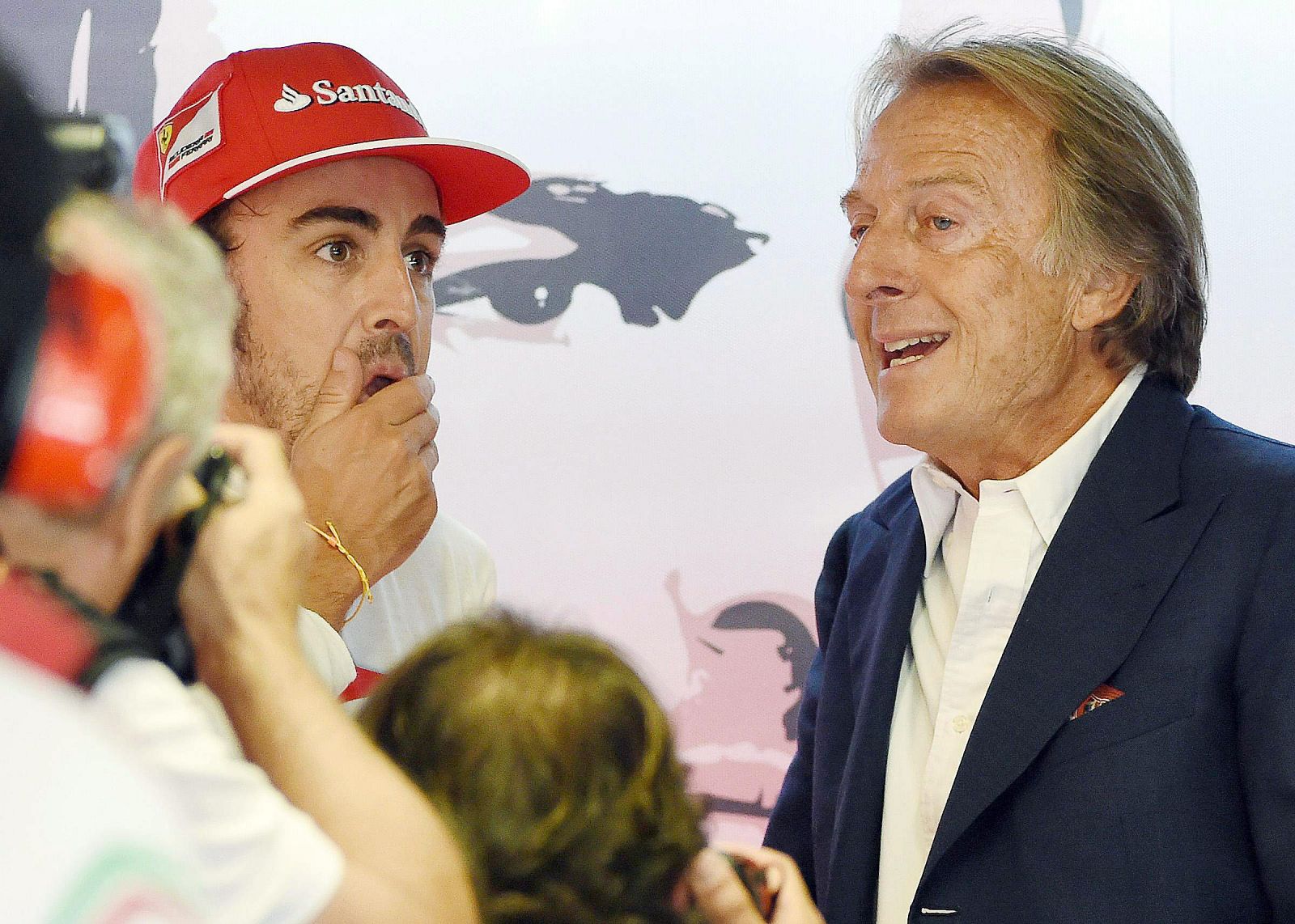 El presidente de Ferrari, Luca Cordero di Montezemolo (D), habla con Fernando Alonso.