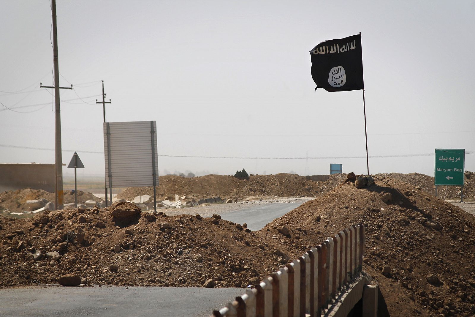 Una bandera del Estado Islámico ondea en un puente en el frente de batalla entre los kurdos Peshmerga y los militantes islamistas en Rashad