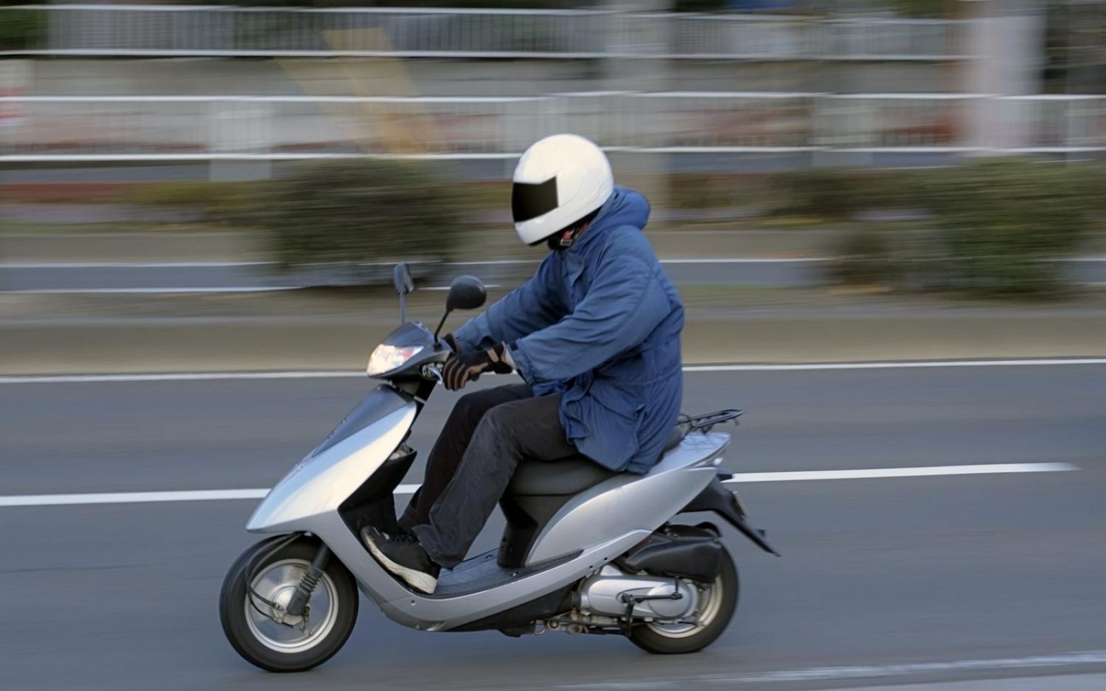 Conductor de scooter con un casco puesto.