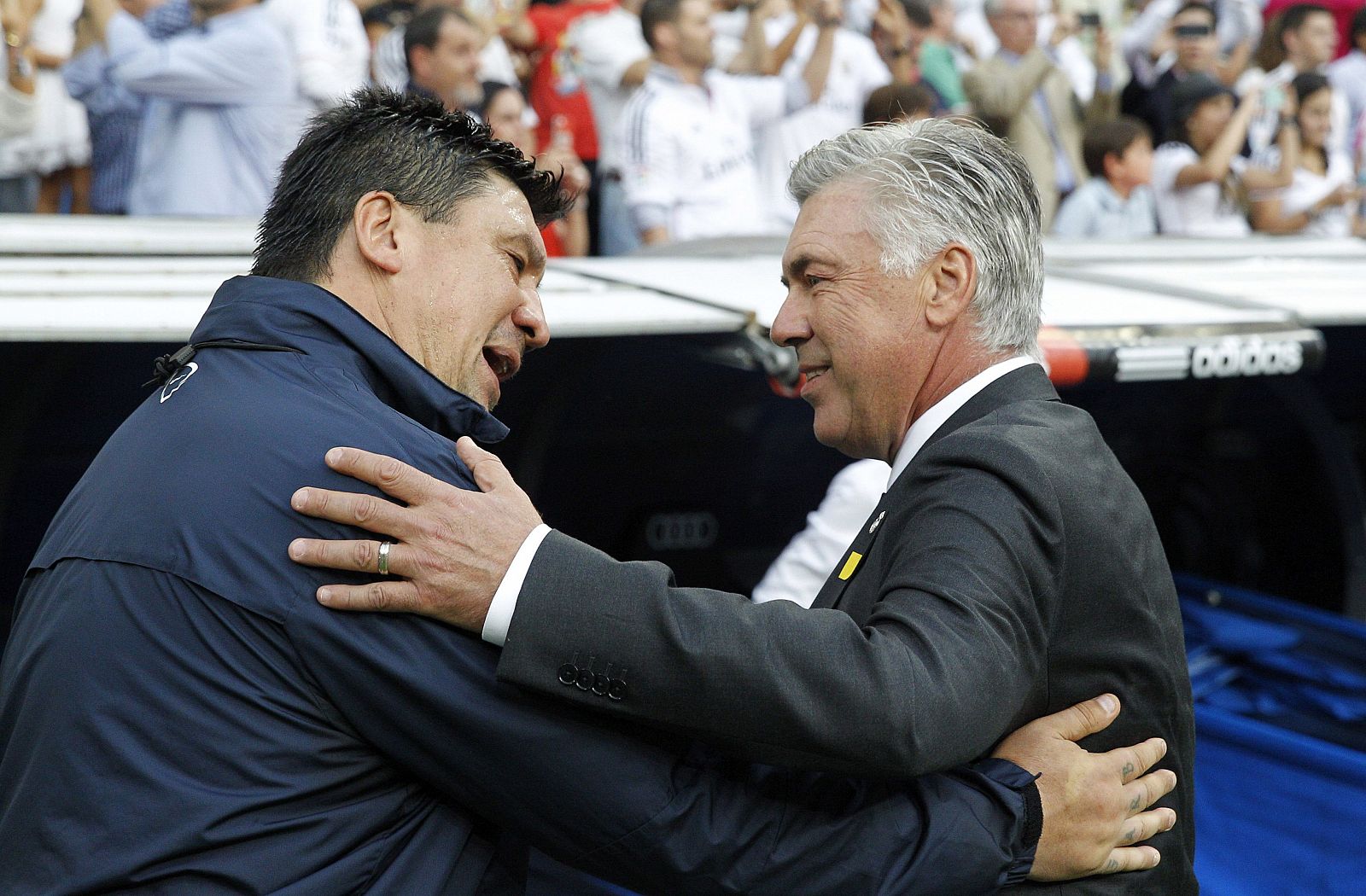 El entrenador italiano del Real Madrid, Carlo Ancelotti (d), saluda al segundo entrenador del Atlético de Madrid, Germán 'Mono' Burgos (i)