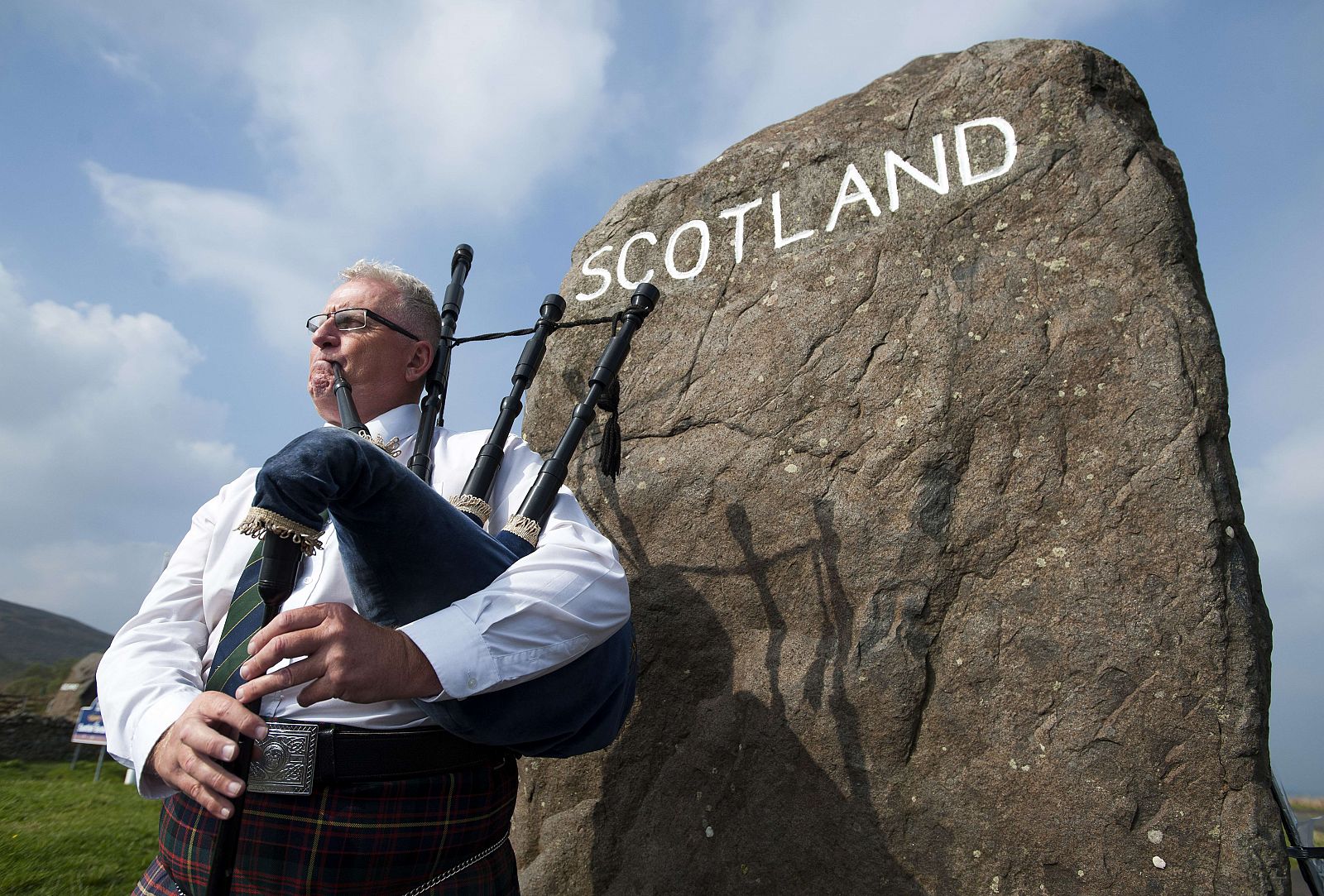 Un músico intepreta con la gaita una canción ante varios visitantes en el pueblo de Selkirk, en la frontera de Escocia e Inglaterra