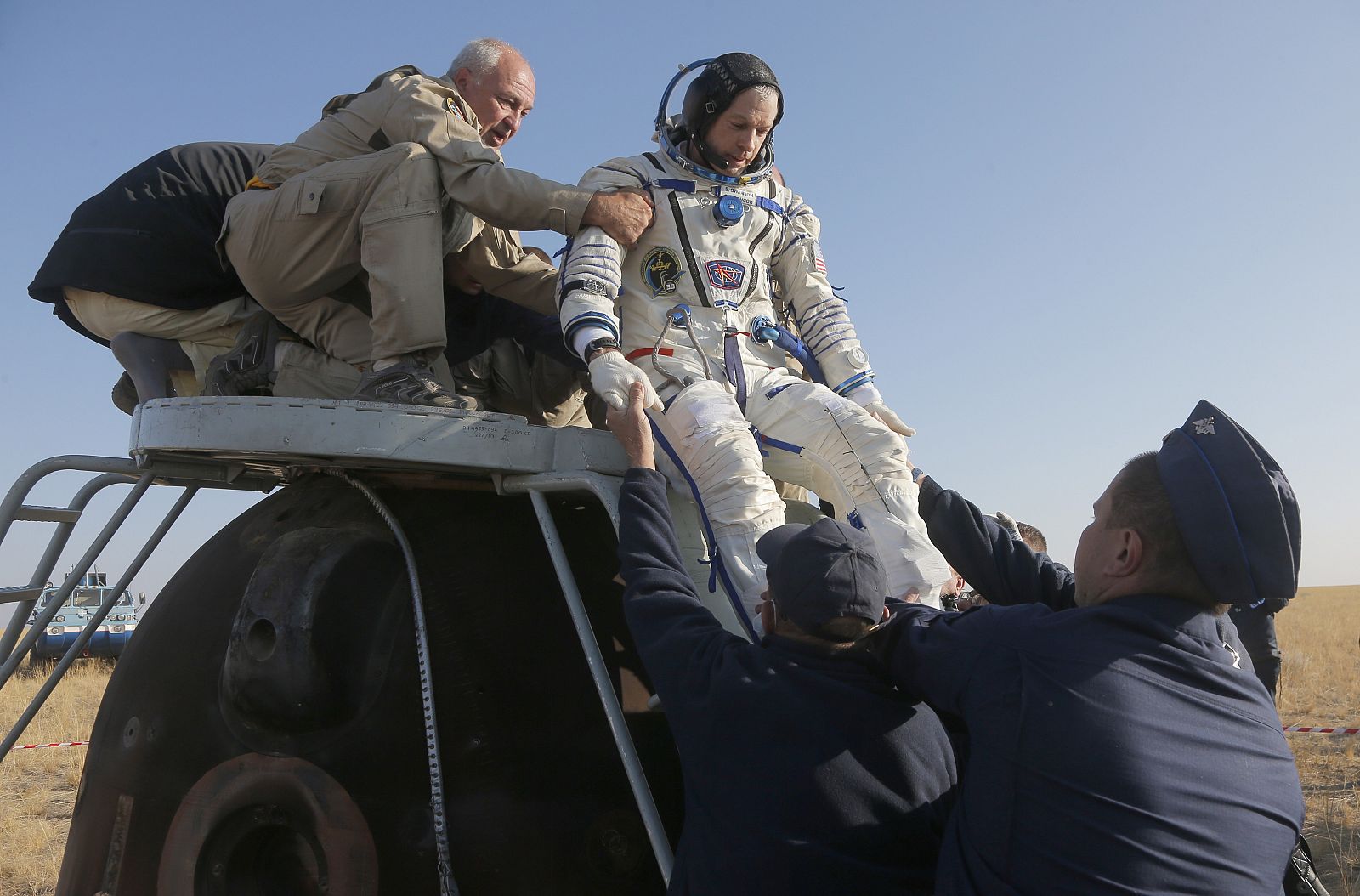 Un astronauta estadounidense desciende de una cápsula Soyuz tras el aterrizaje de vuelta a la tierra.