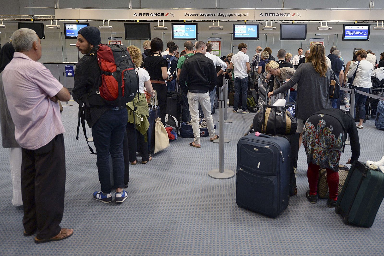 Fila de viajeros ante los mostradores de facturación del aeropuerto de Marsella