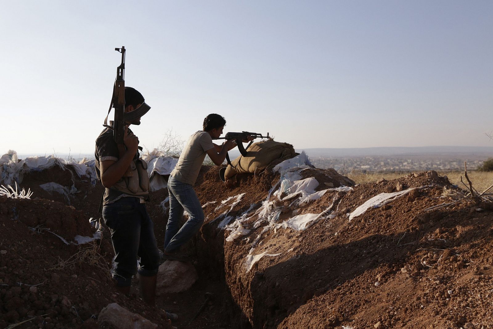 Armed Free Syrian Army fighters stand on one of the frontlines of Wadi Al-Dayf camp in the southern Idlib countryside
