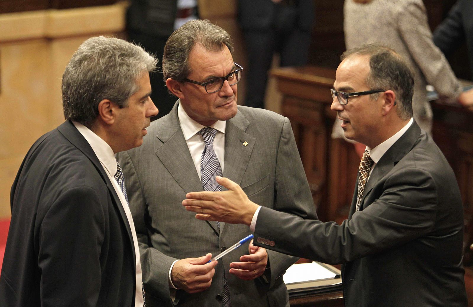 El presidente de la Generalitat, Artur Mas (c) habla con el conseller de la Presidencia, Francesc Homs (i) y el portavoz del grupo parlamentario de CiU, Jordi Turull (d).
