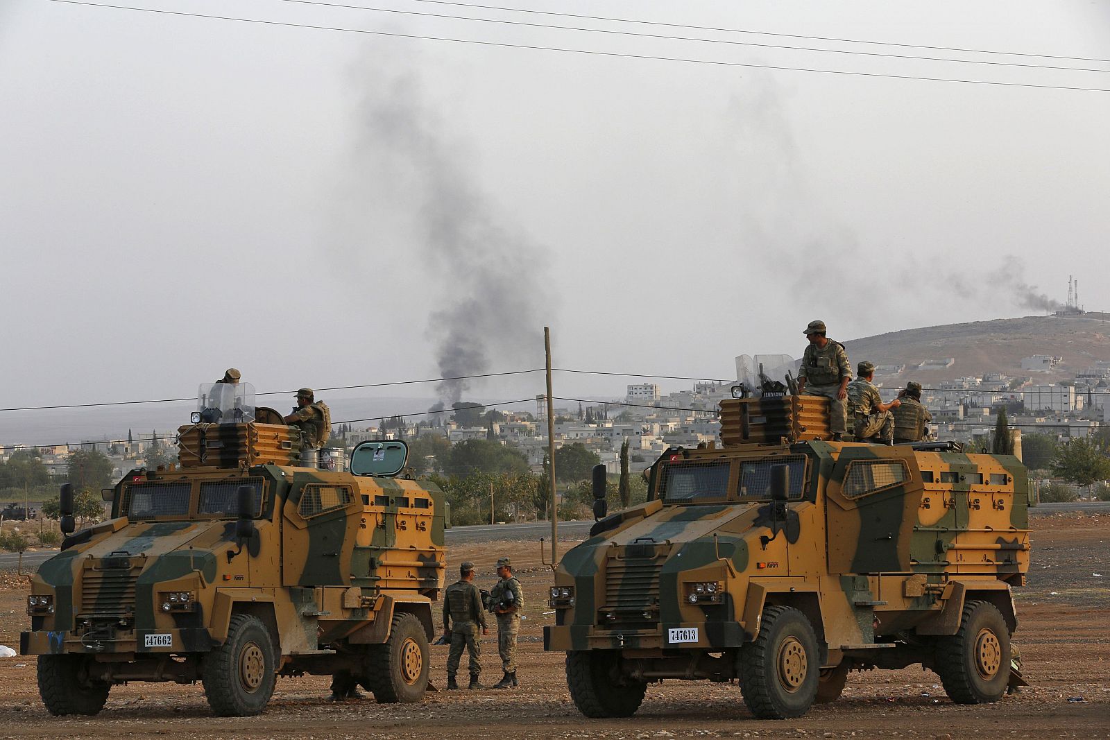 Turkish soldiers are seen with armoured vehicles near the Mursitpinar border crossing on the Turkish-Syrian border