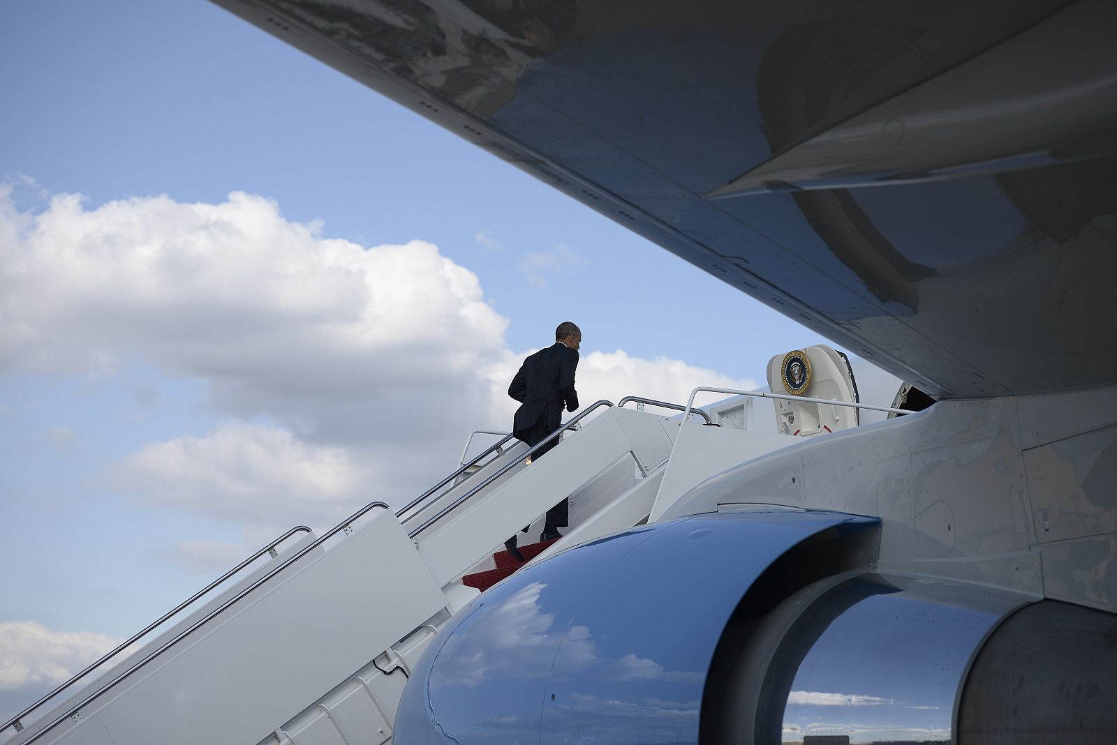 El presidente de EE.UU., Barack Obama, sube en solitario las escalerillas del Air Force One antes de dirigirse a un acto de campaña.