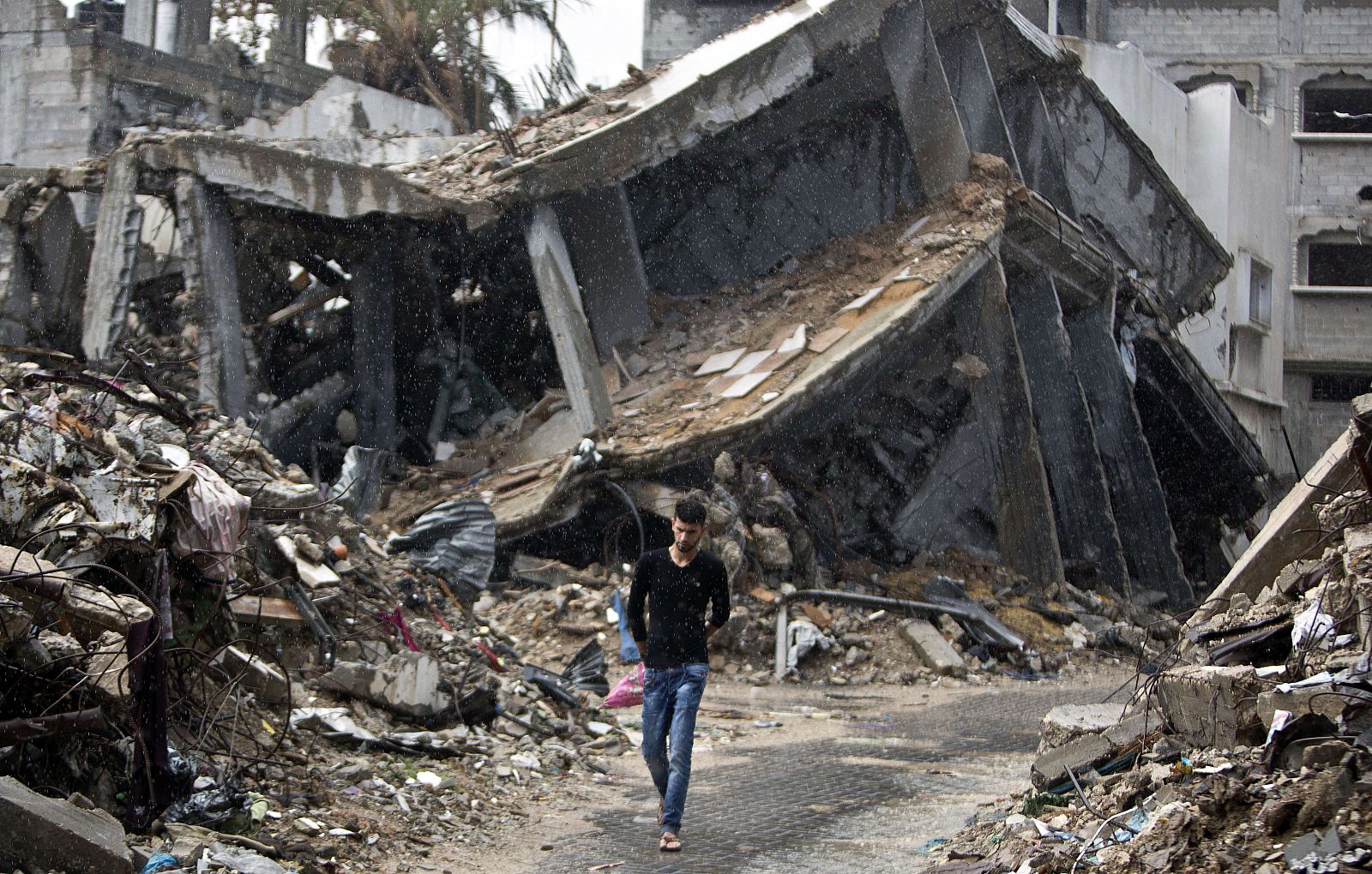 Un palestino pasea entre los escombros de los edificios destruidos en la útlima operación militar israelí en Gaza.