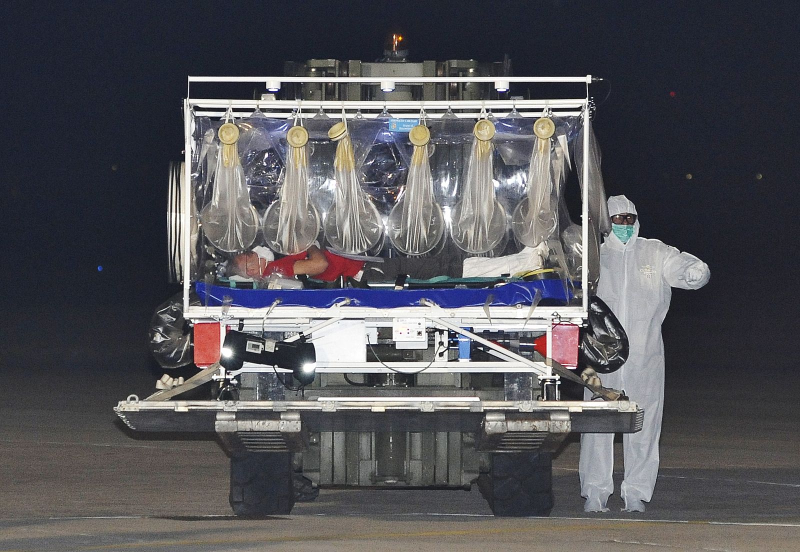 El doctor italiano infectado de ébola es trasladado en una camilla aislada a su llegada al aeropuerto de Pratica di Mare, cerca de Roma