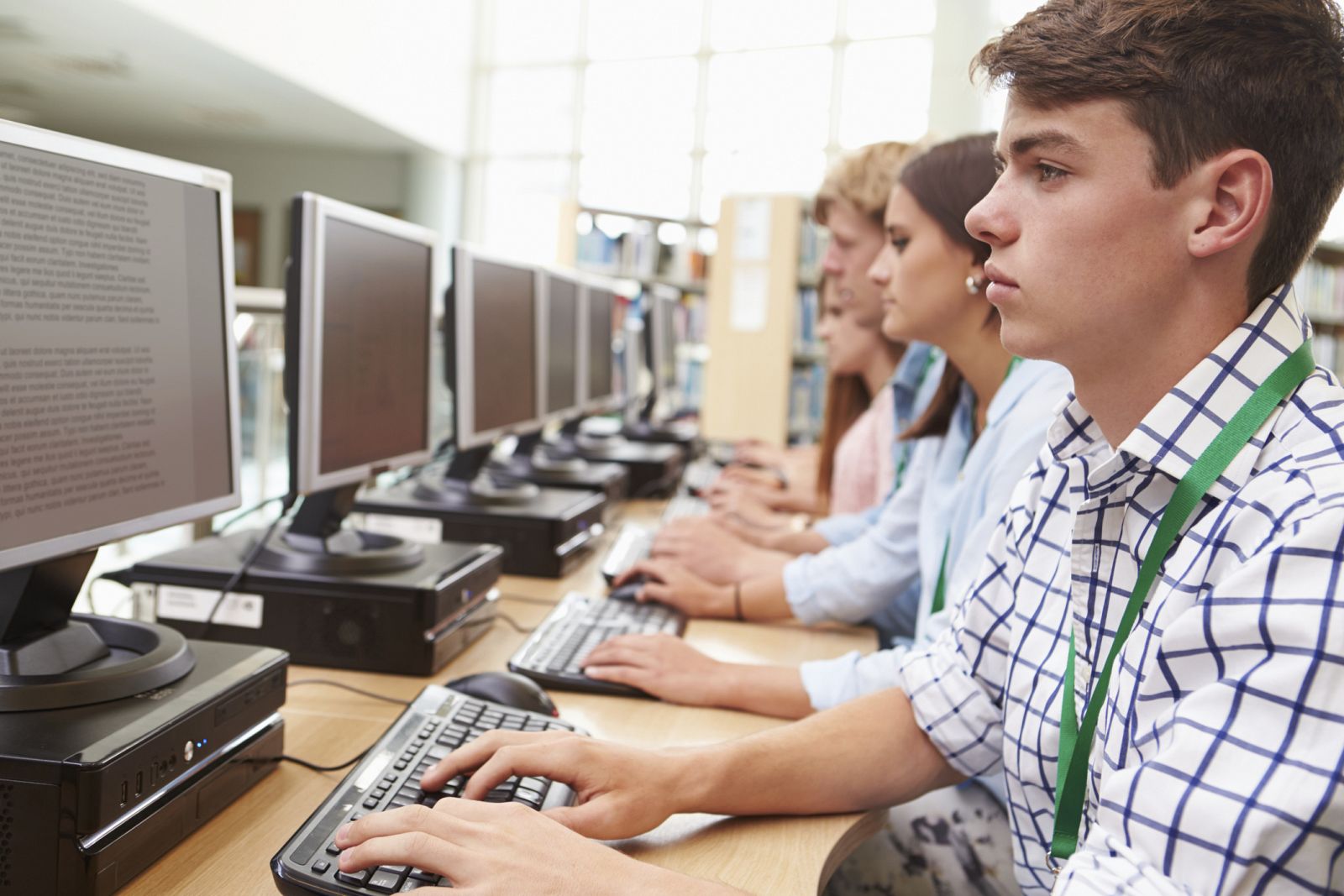 Estudiantes trabajando en los ordenadores de una biblioteca.