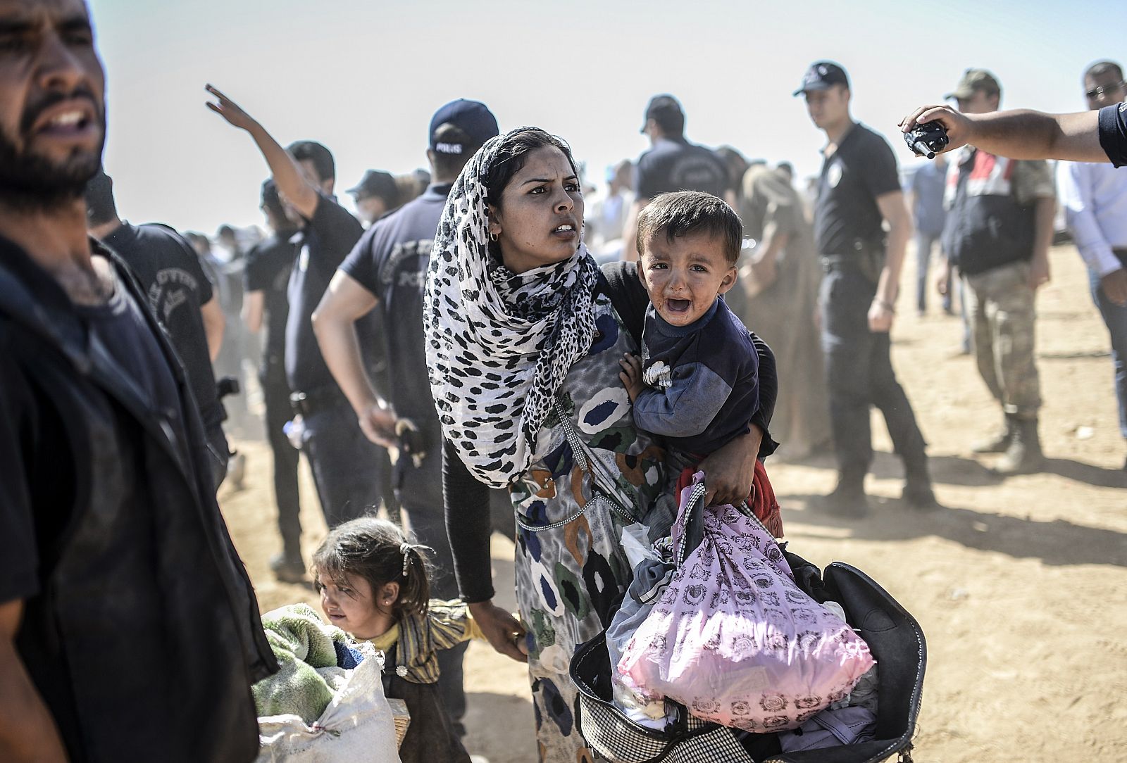 Una mujer kurda de Siria cruza la frontera entre Siria y Turquía
