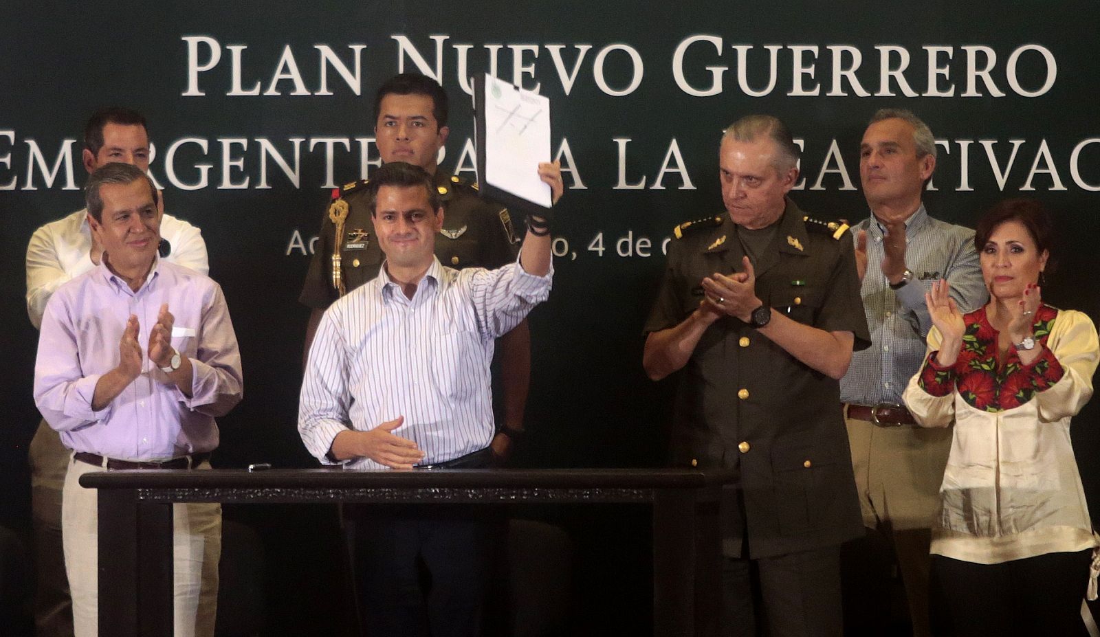 El presidente mexicano, Enrique Peña Nieto, muestra el documento del plan para un "Nuevo Gierrero" en su visita a Acapulco.