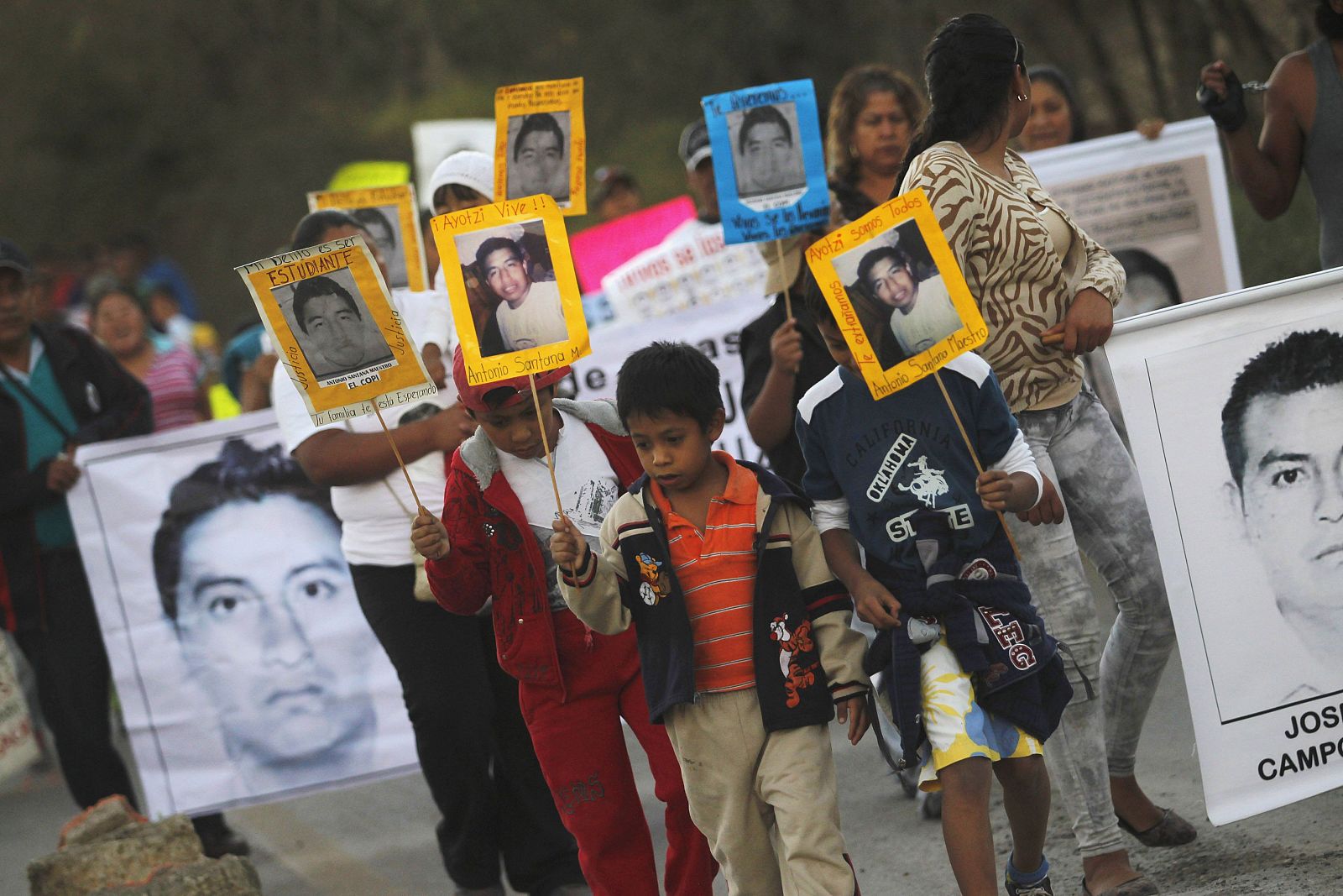 Un grupo de niños marcha portando fotos de los desaparecidos en Iguala.