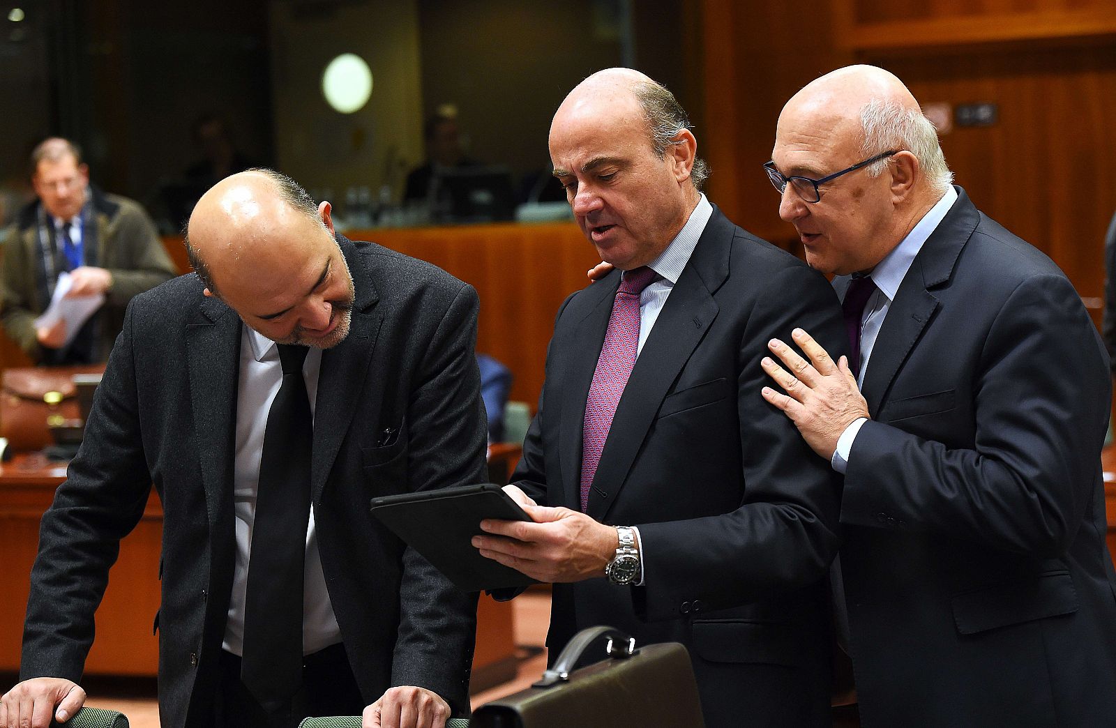 De Guindos muestra un documento a su homólogo francés, Michel Sapin, y al comisario Moscovici