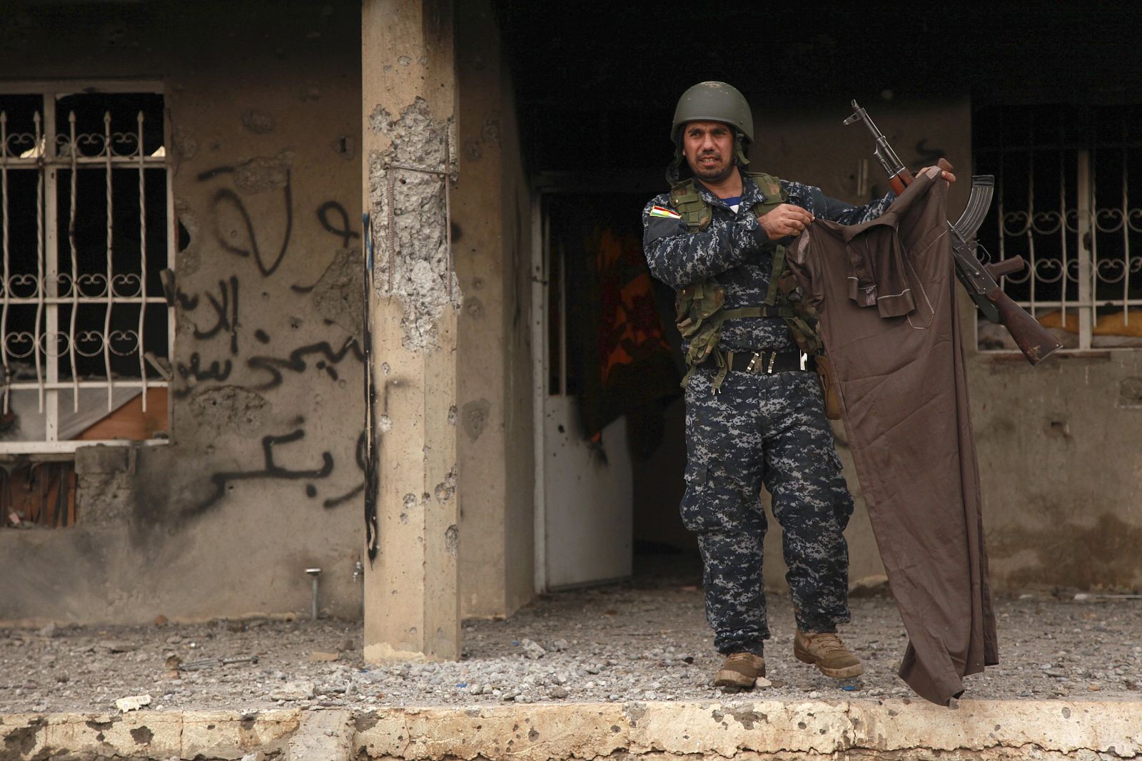Un kurdo muestra las ropas de un miembro del Estado islámico en Kesarej