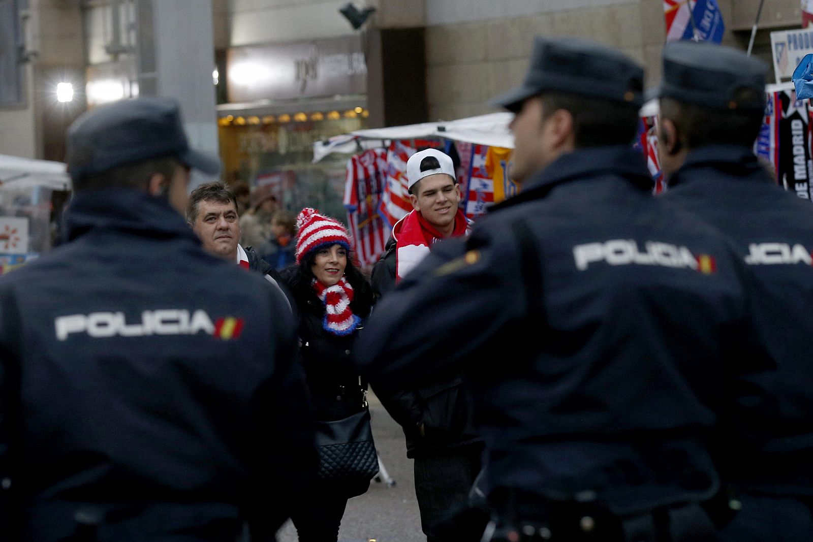 Dispositivo policial ante unos aficionados rojiblancos en el exterior del estadio Vicente Calderón, en Madrid.
