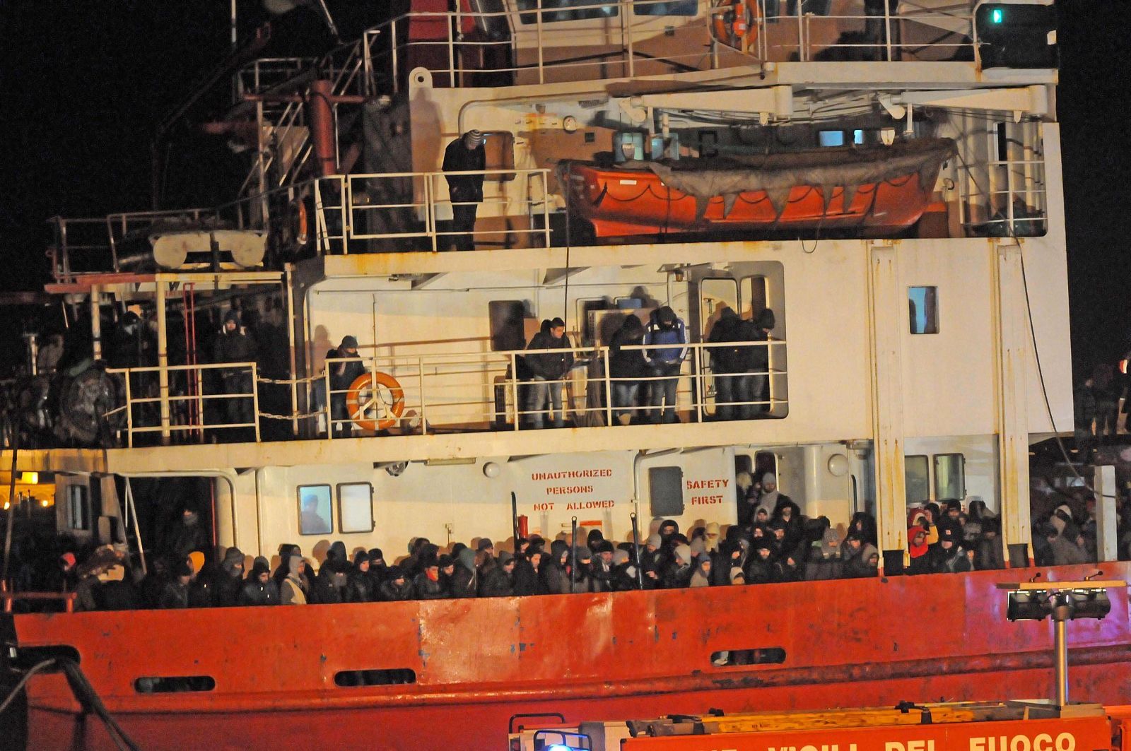 Cientos de migrantes abarrotan la cubierta en el buque Blue Sky a su llegada al puerto italiano de Gallipoli.