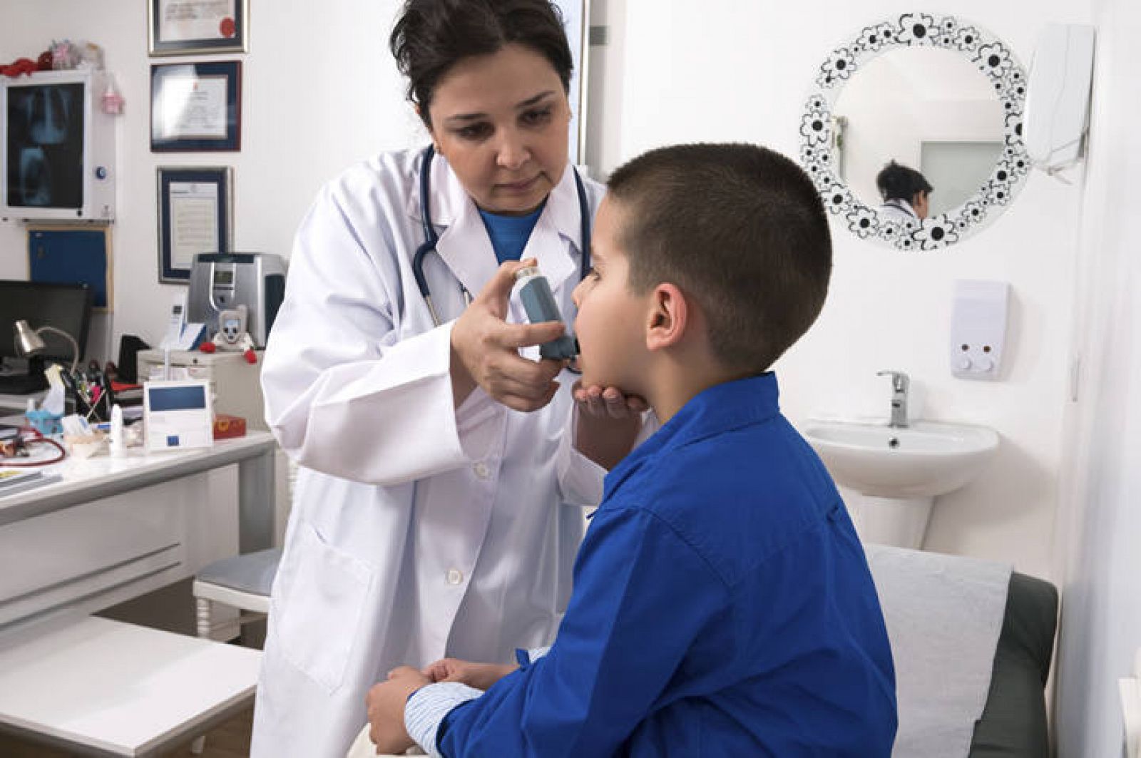  Una doctora aplica un broncodilatador a un niño con asma.