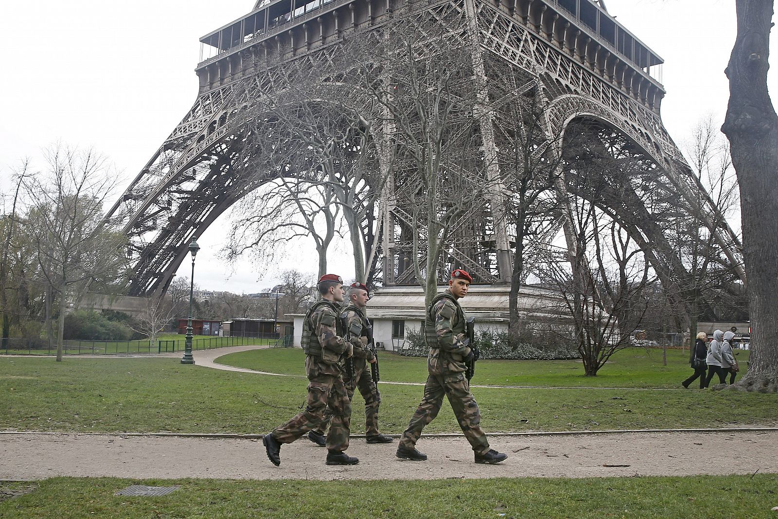 Varios soldados pasean cerca de la Torre Eiffel, en París (Francia).