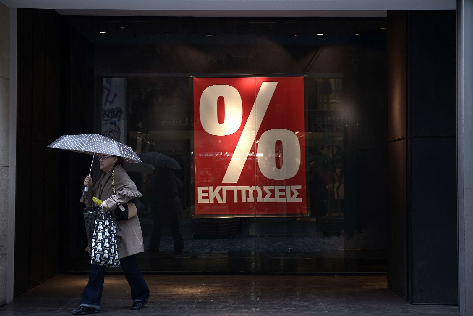 Una mujer sale de una tienda en Atenas durante el período de rebajas