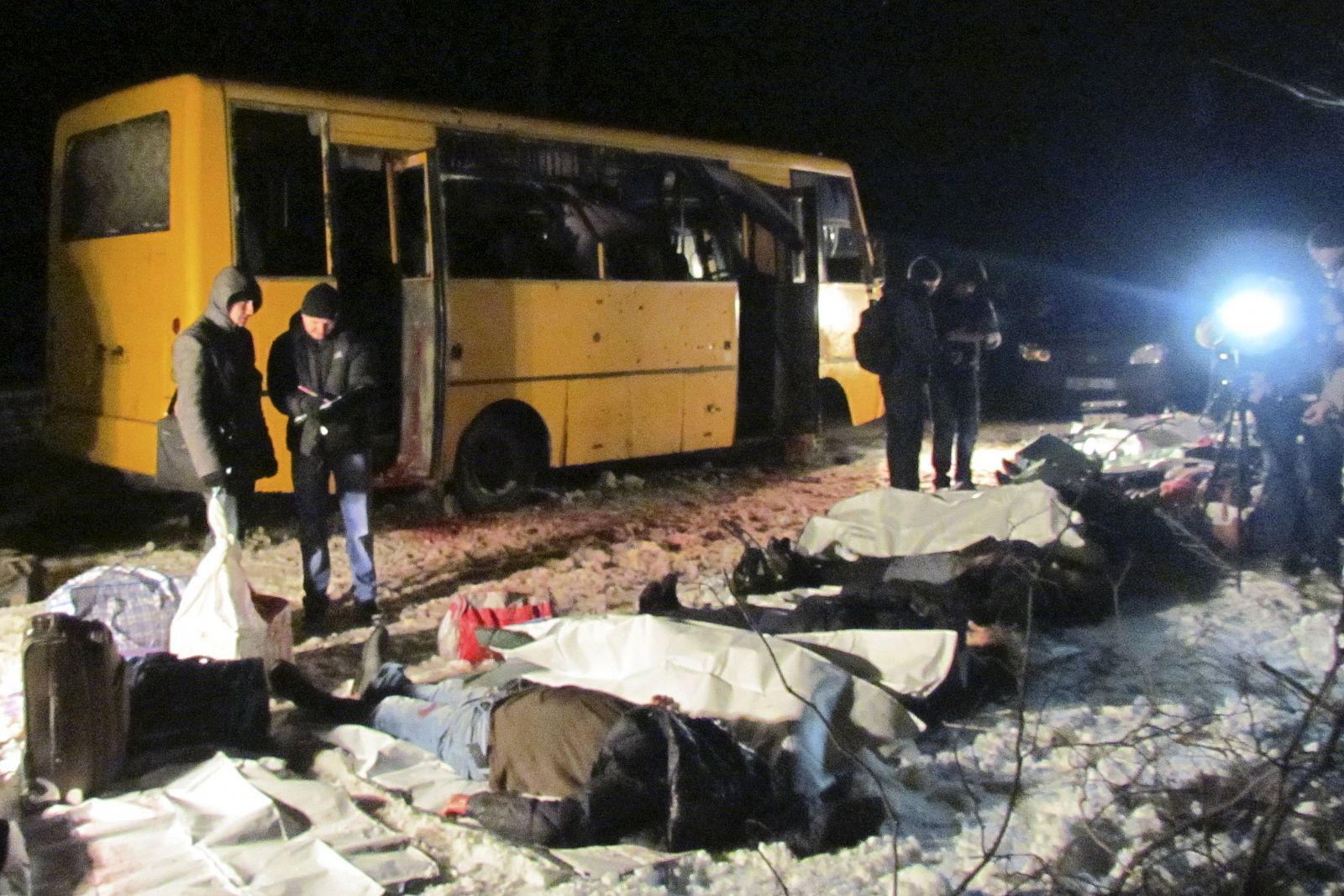 Pasajeros yacen junto al autobús atacado en Volnovaja, Donetsk, el martes por la noche.