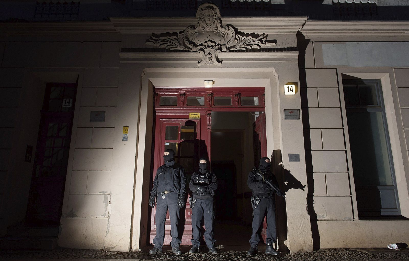 Miembros de la policía antiterrorista hacen guardia a las puertas de un edificio de apartamentos en la calle Perleberger en Berlín (Alemania)