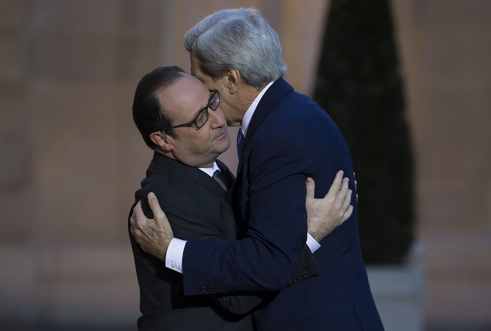 Hollande (izda) saluda a John Kerry a su llegada al Palacio del Elíseo