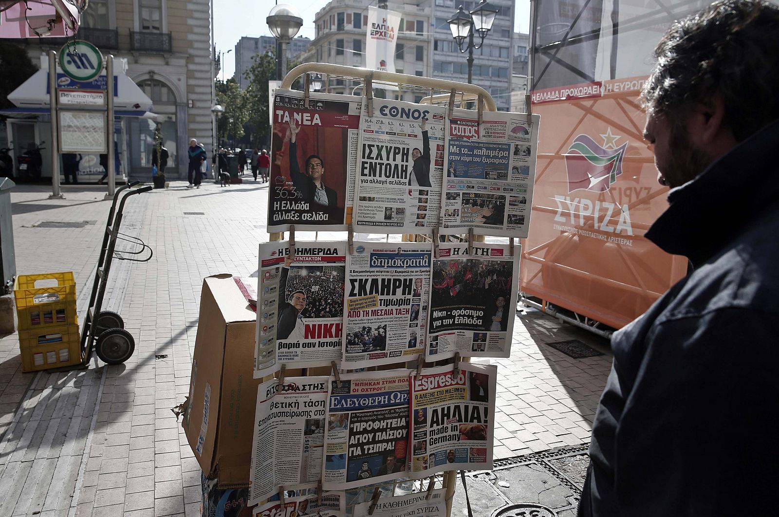 Un hombre lee la prensa griega expuesta en un quiosco de Atenas