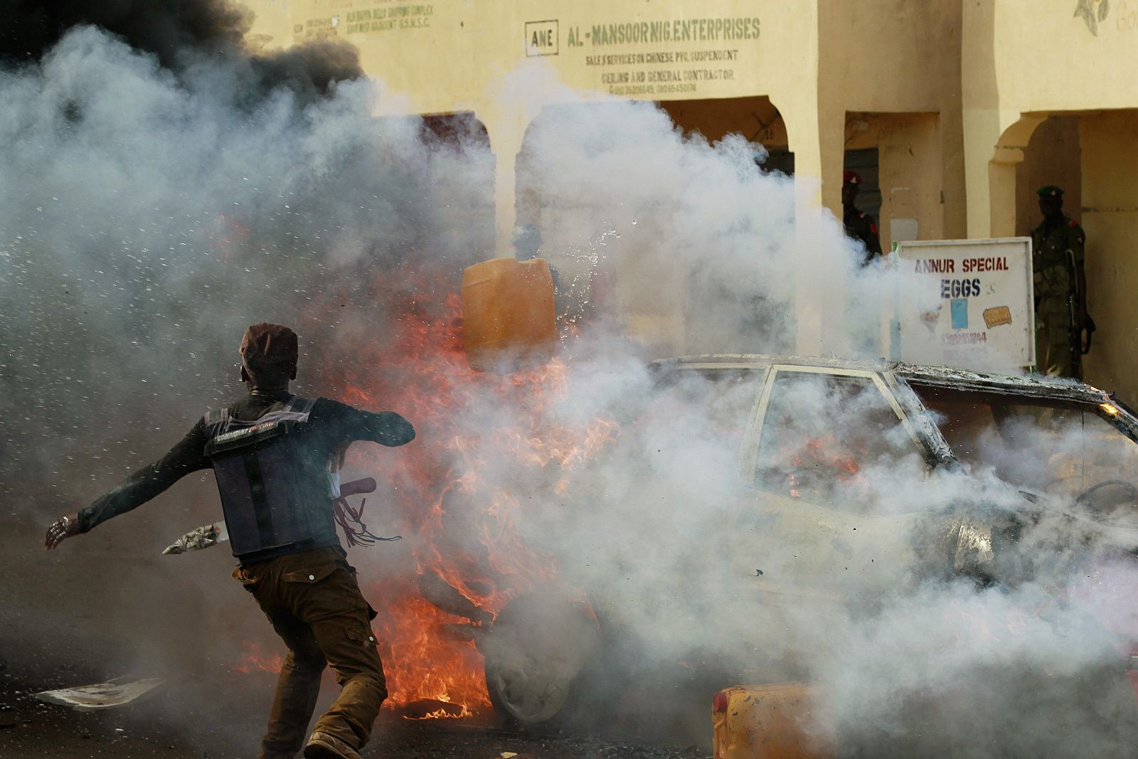 Un hombre intenta apagar las llamas del coche bomba en el estadio de Gombe, Nigeria.