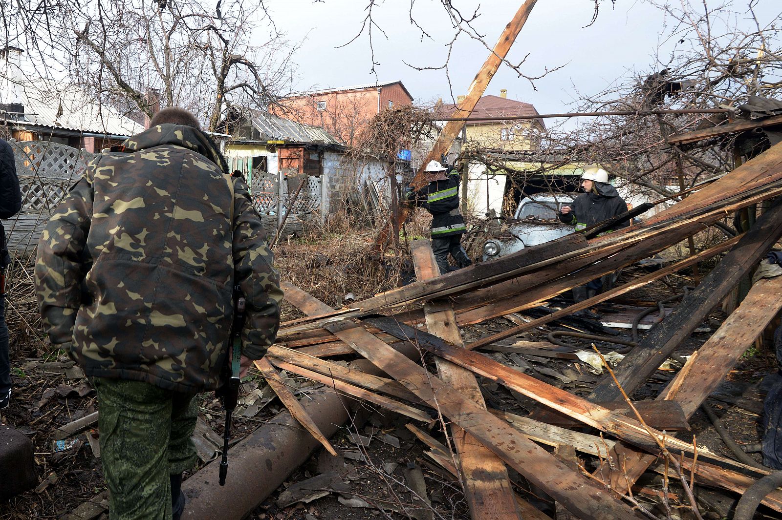 Un soldado prorruso camina cerca de una casa destruida después de los bombardeos