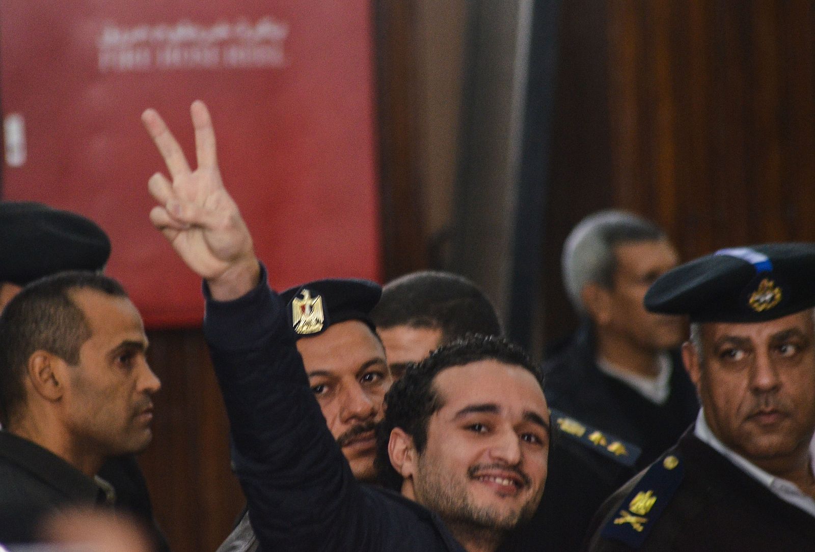 El activista Ahmed Douma hace la señal de la victoria durante el juicio en el que ha sido condenado a cadena perpetua.