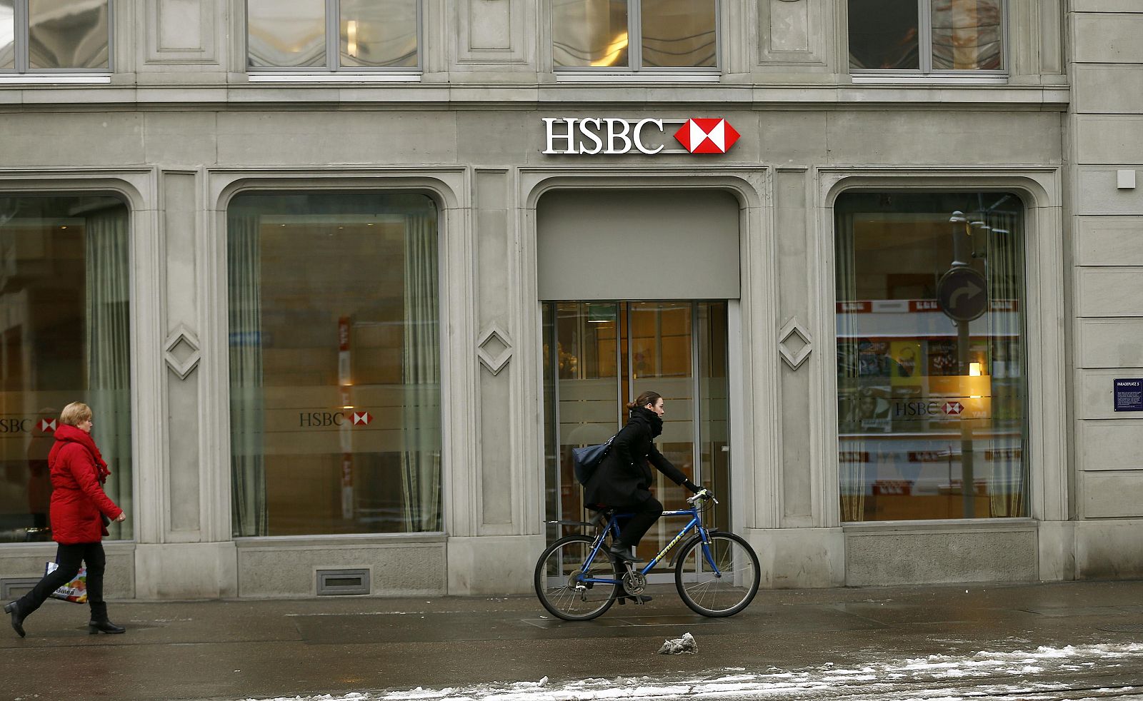 Una ciclista pasa por delante de una sede del HSBC en Zurich