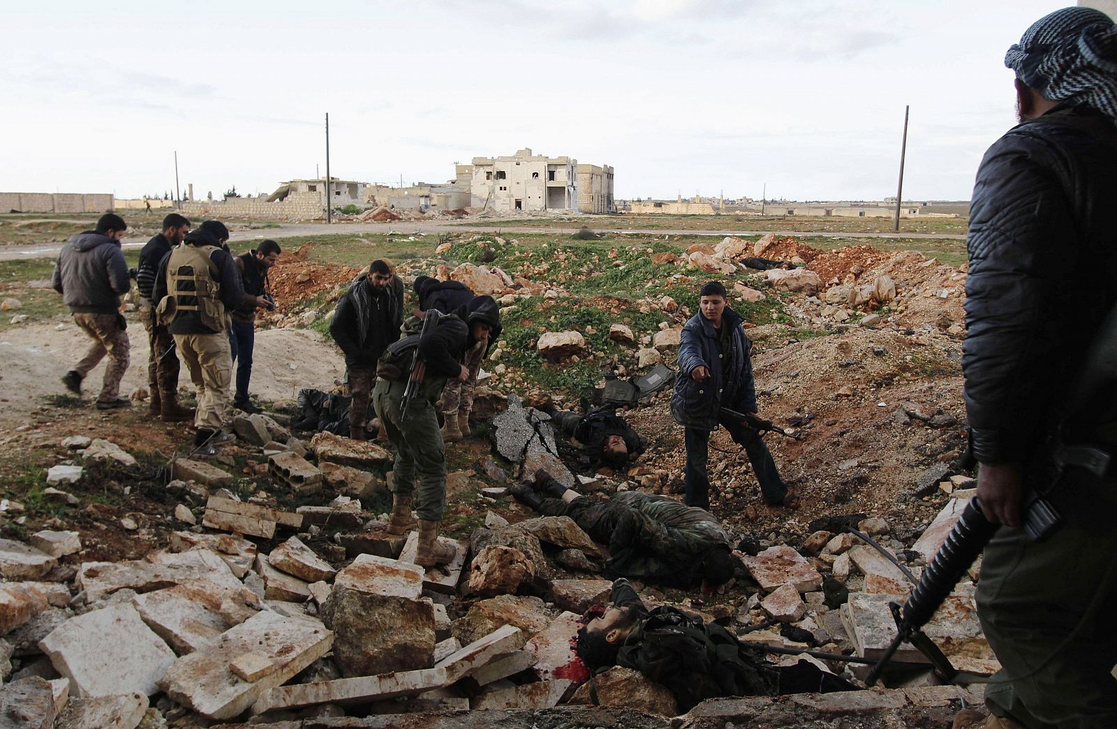 Rebel fighters of al-Jabha al-Shamiya (the Shamiya Front) look at dead bodies, which according to them were forces loyal to Syria's President Bashar al-Assad, after heavy clashes in al-Mallah area north of Aleppo